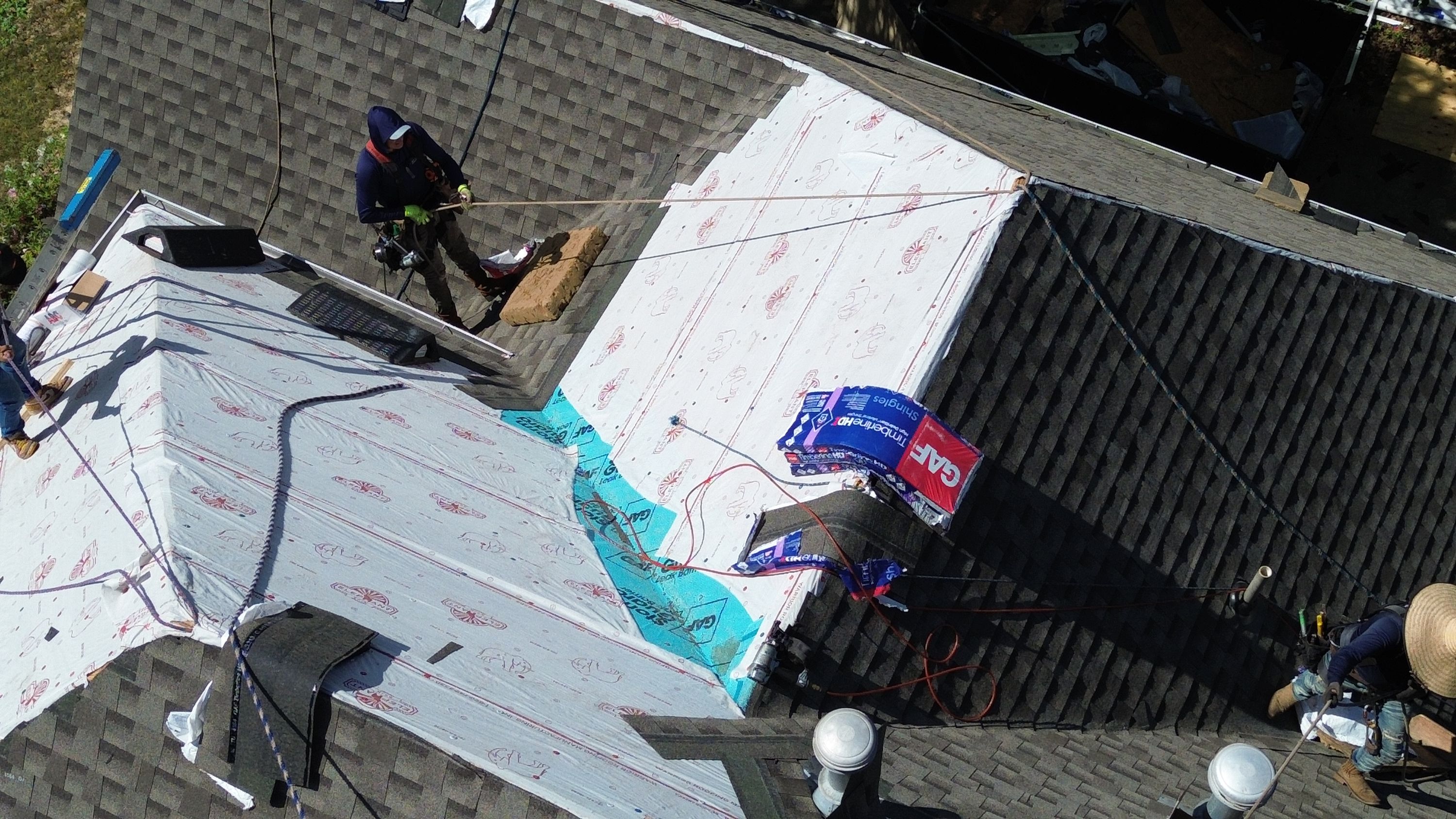 Patriot laying GAF synthetic underlayment and shingles during a roof replacement in Hoover.