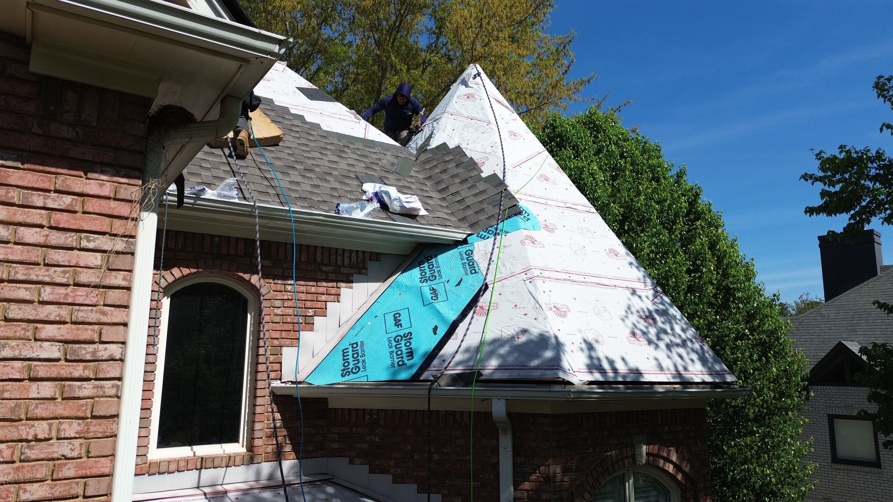 Patriot applying GAF StormGuard leak barrier and architectural shingles during a Hoover roof replacement.