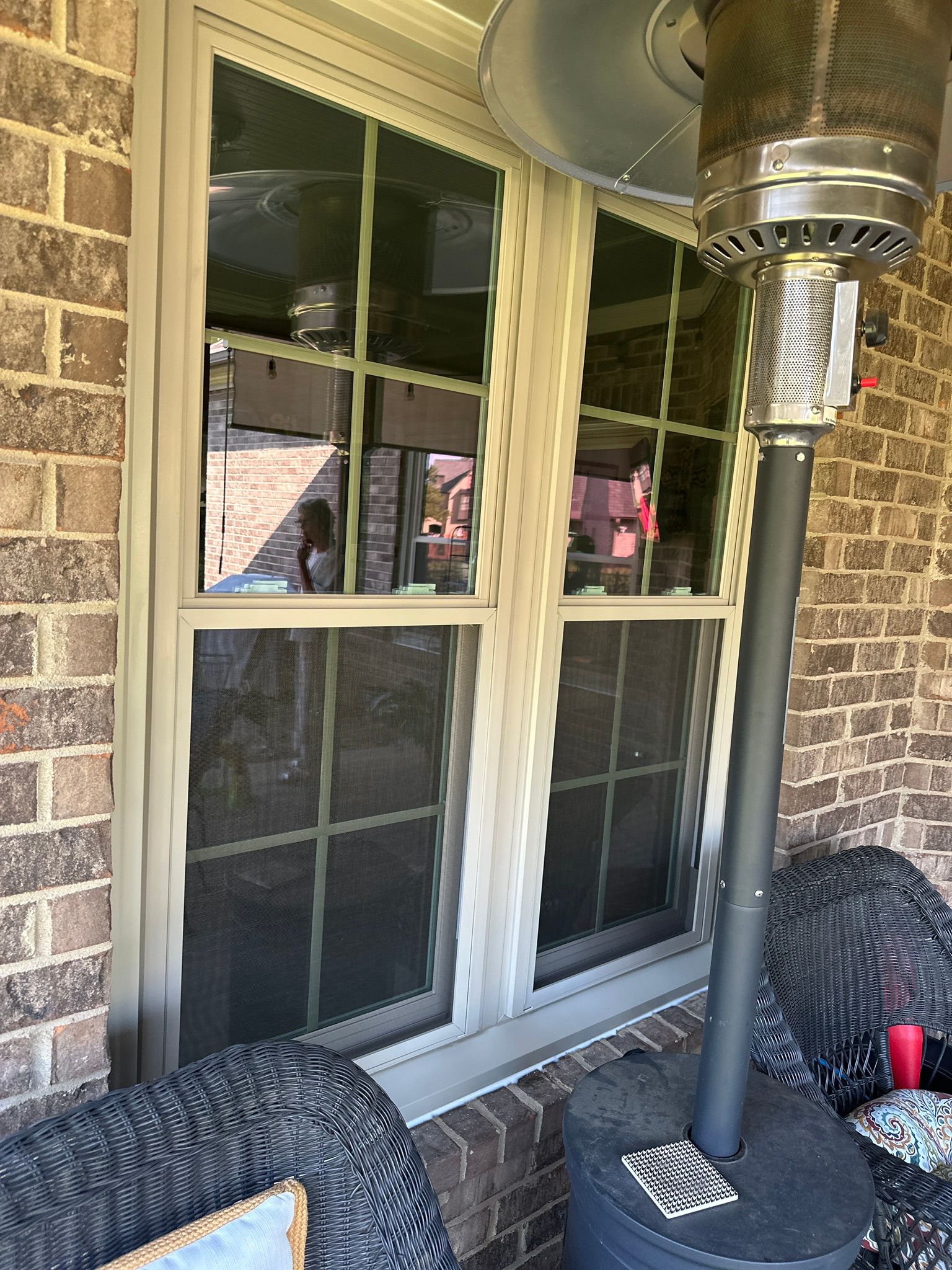 A newly installed double-hung window with a tan frame on a brick home in the Bluff Park neighborhood of Hoover.