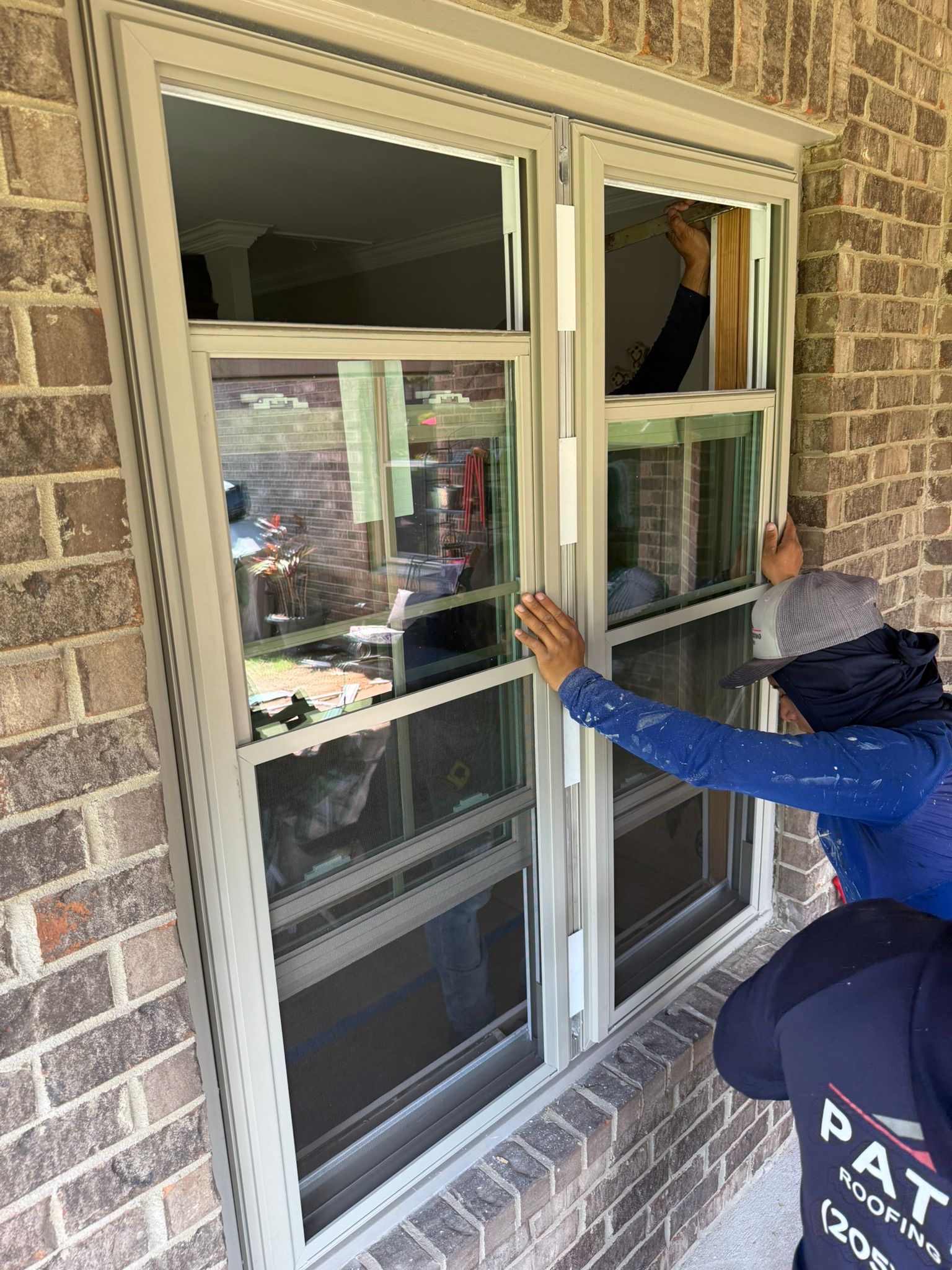 A new vinyl double-hung window being installed in a brick home in the Bluff Park neighborhood of Hoover.