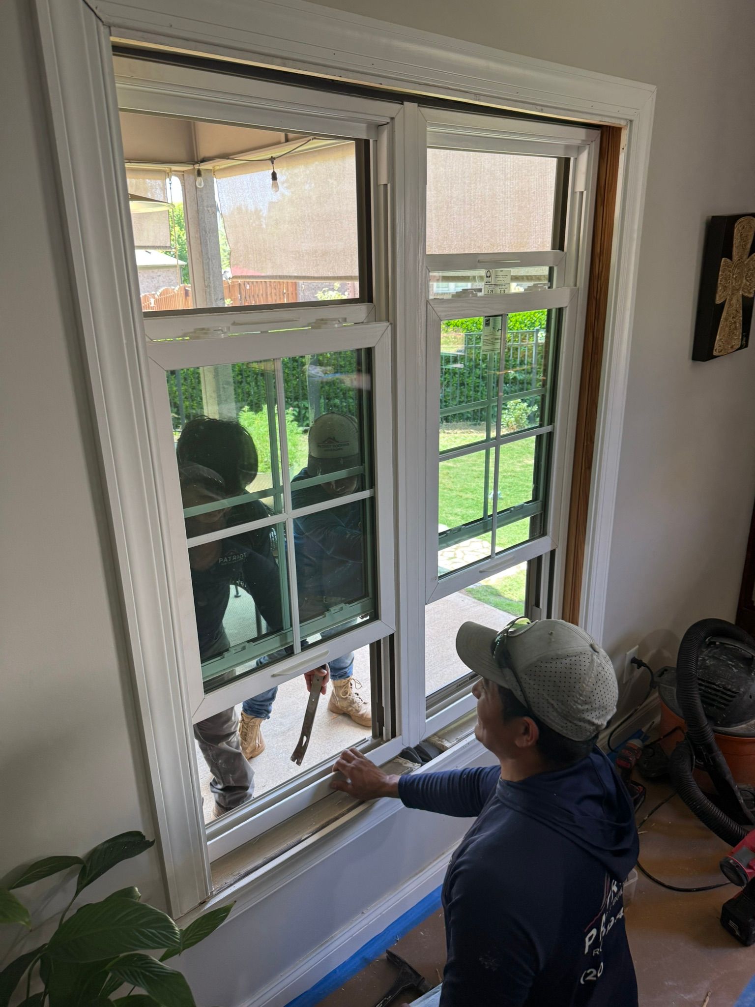 A new white vinyl double-hung window installation underway in a Bluff Park home.