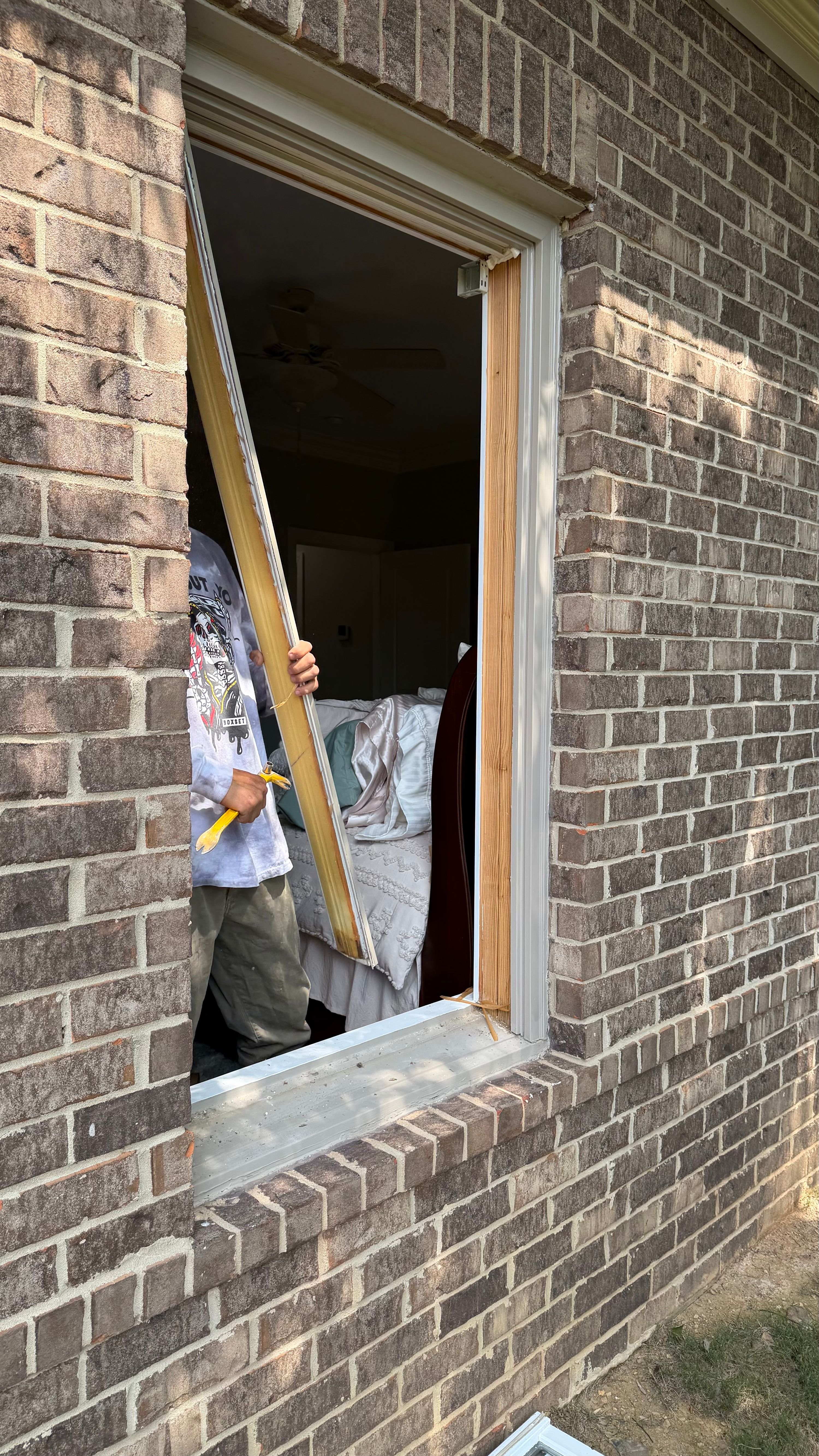 Removing an old window frame during a residential window replacement project in the Bluff Park neighborhood of Hoover.