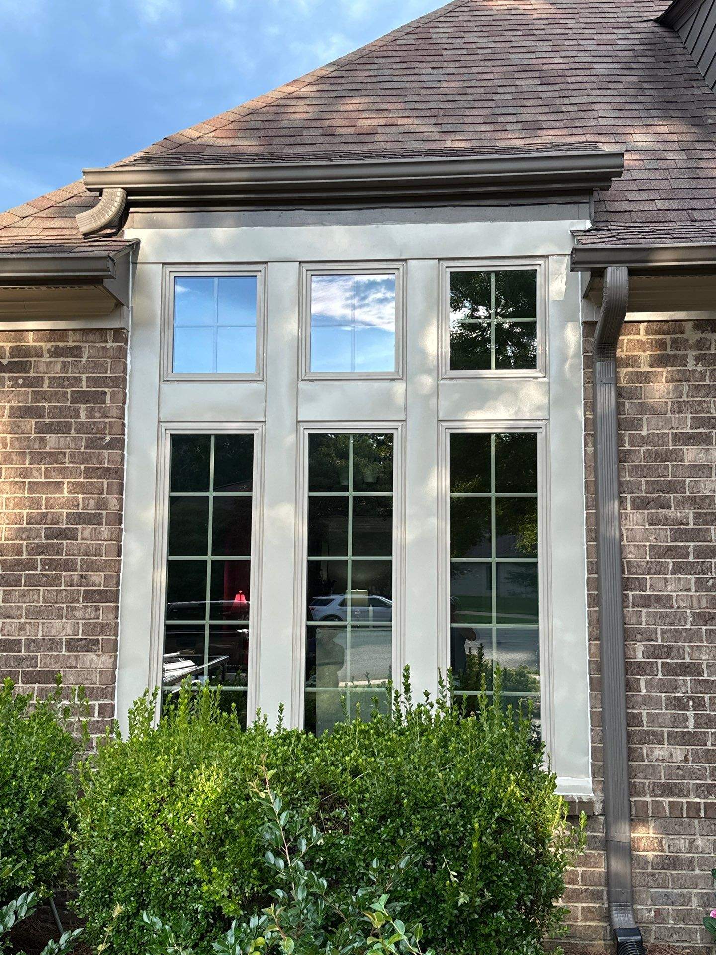 Clean beige trim frames three vertical grid-style window units during a window replacement in Chapel Creek.