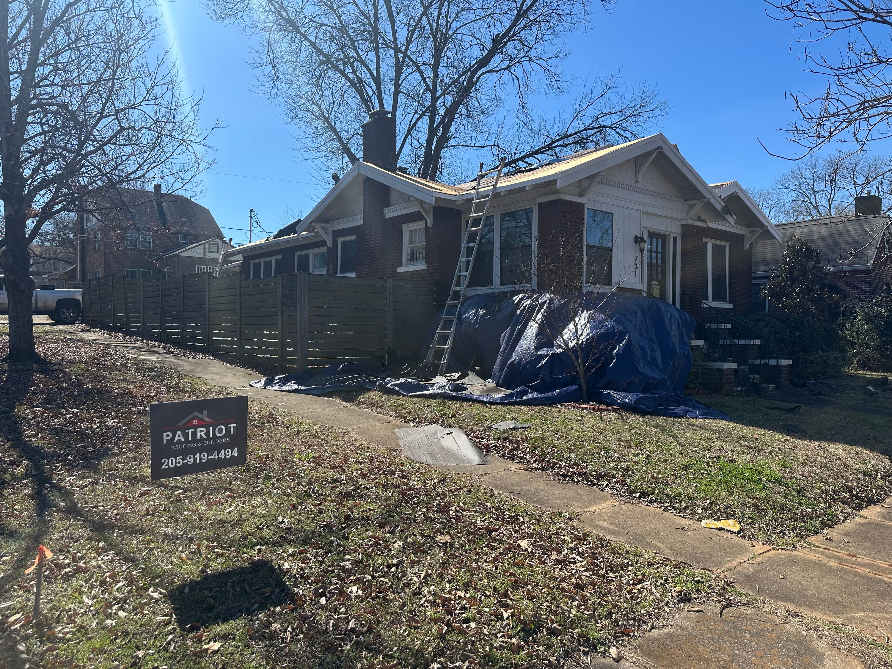 Roof replacement in progress on a brick home in Glen Iris, Birmingham by Patriot Roofing & Builders.