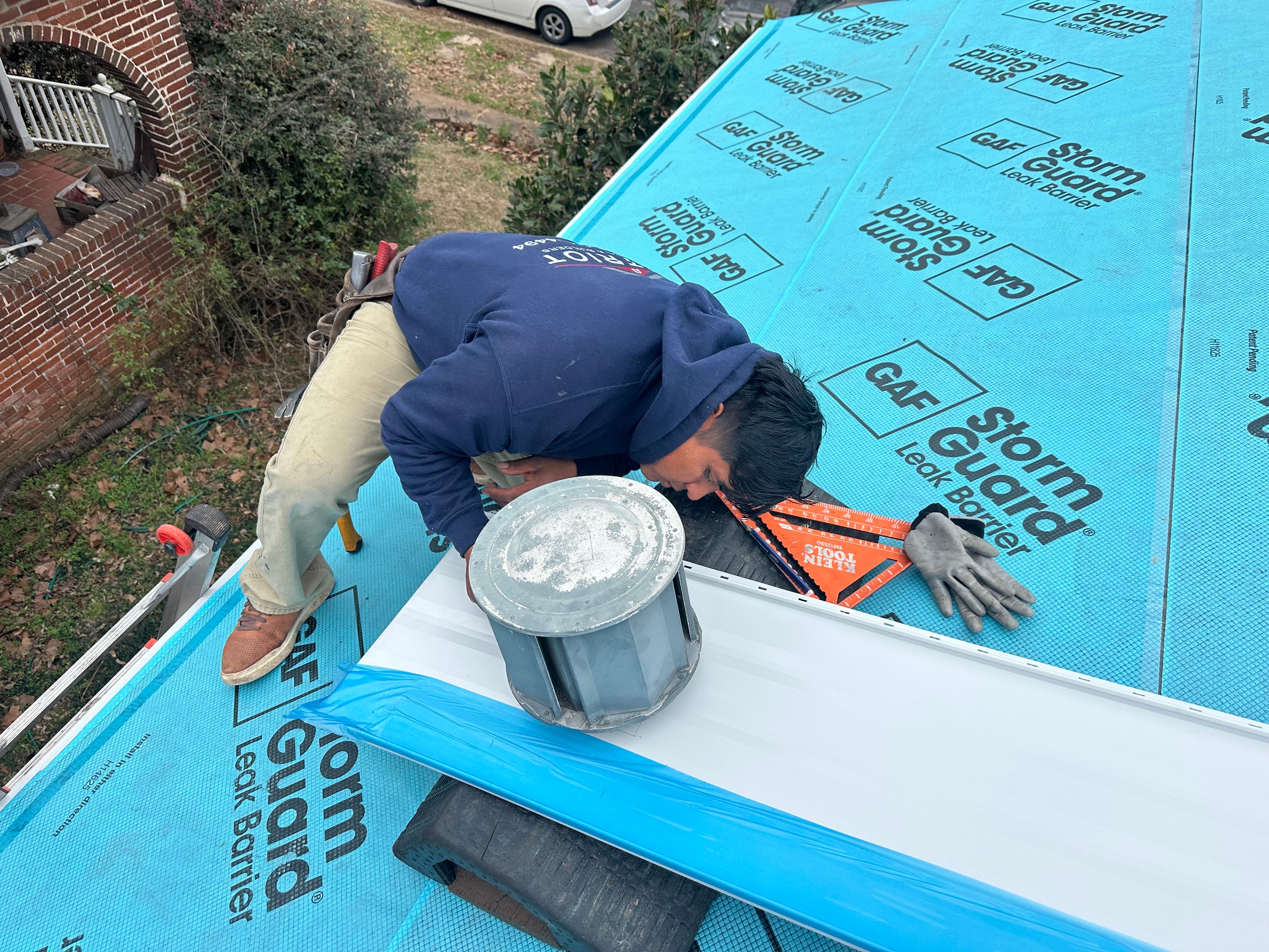 Roofing contractor installing metal flashing over GAF StormGuard during a roof replacement in Glen Iris, Birmingham.
