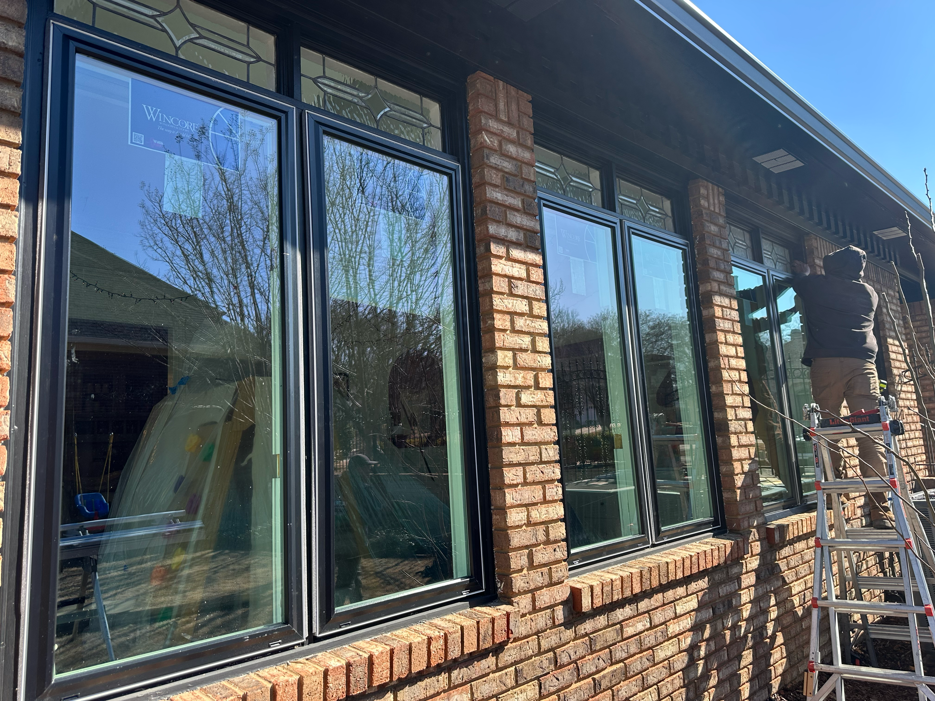 A row of energy-efficient black Wincore windows installed on a brick residence in Hoover, AL.
