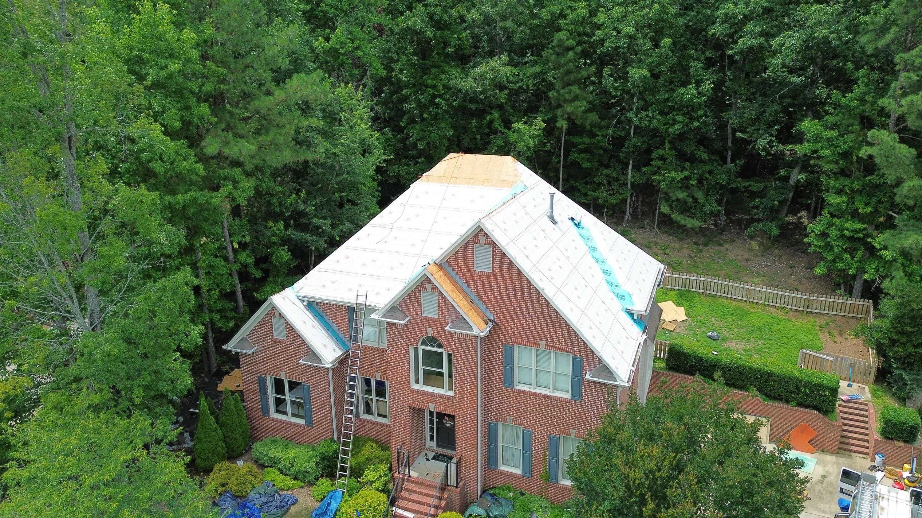 Roof replacement project showing synthetic underlayment on a brick home in Hoover.