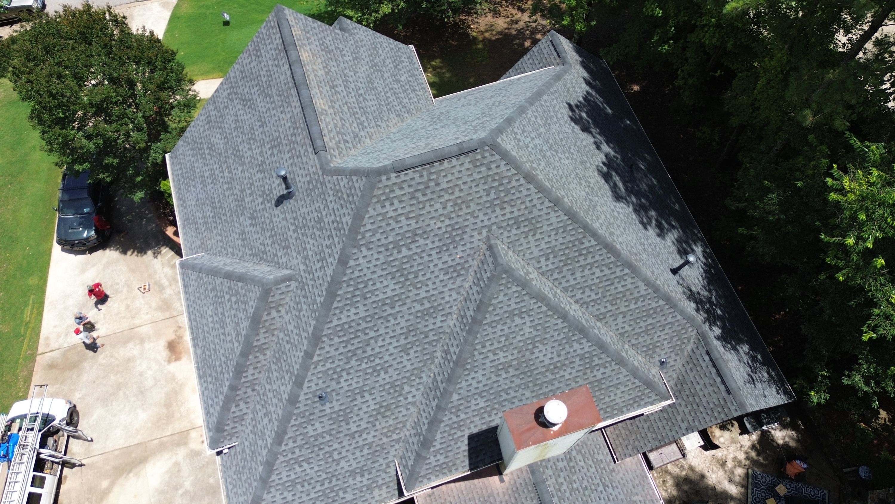 Aerial view of a completed asphalt shingle roof replacement on a home in Hoover.