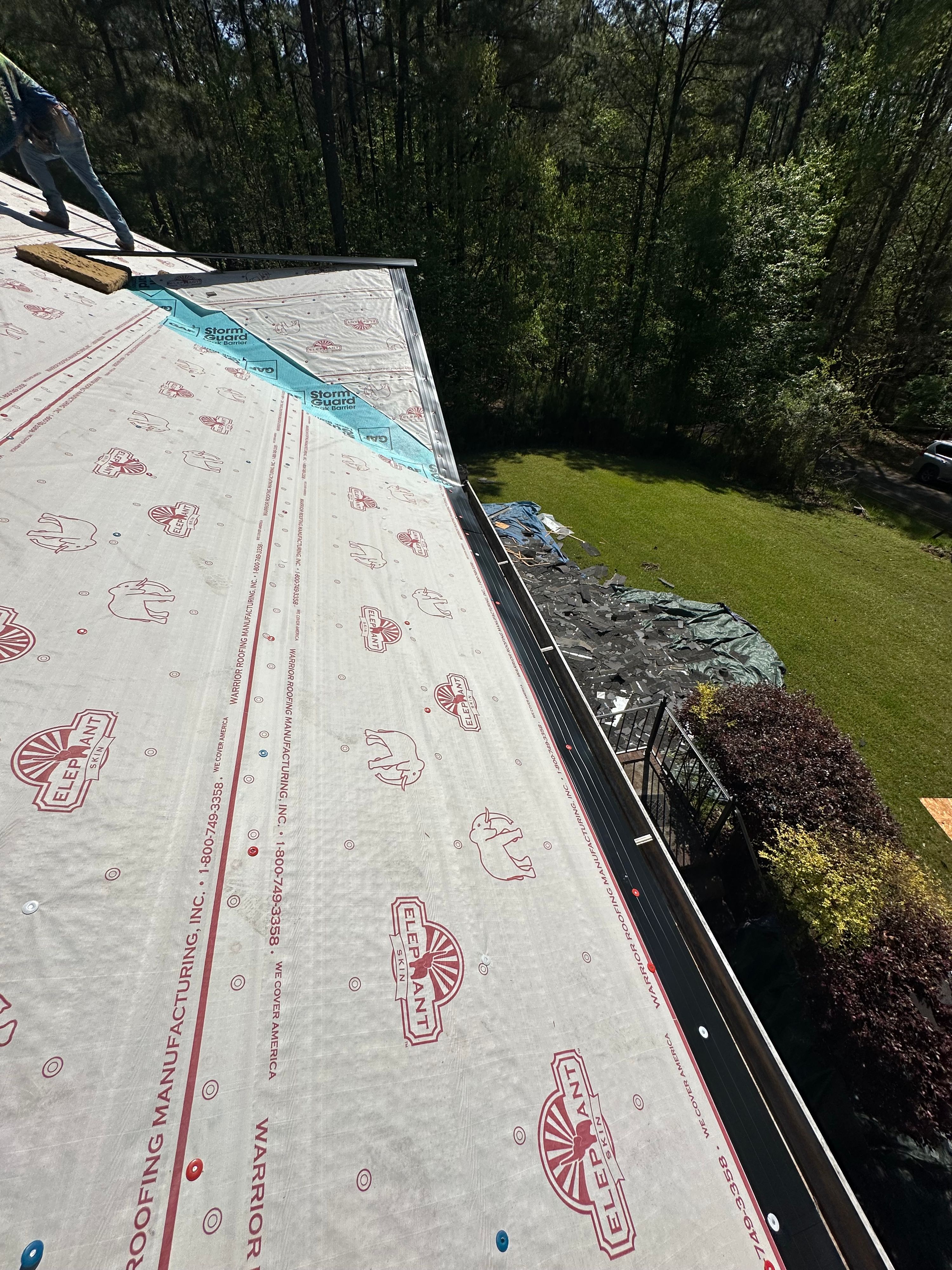 Roof underlayment being installed on a house in Chelsea during a roof replacement project.