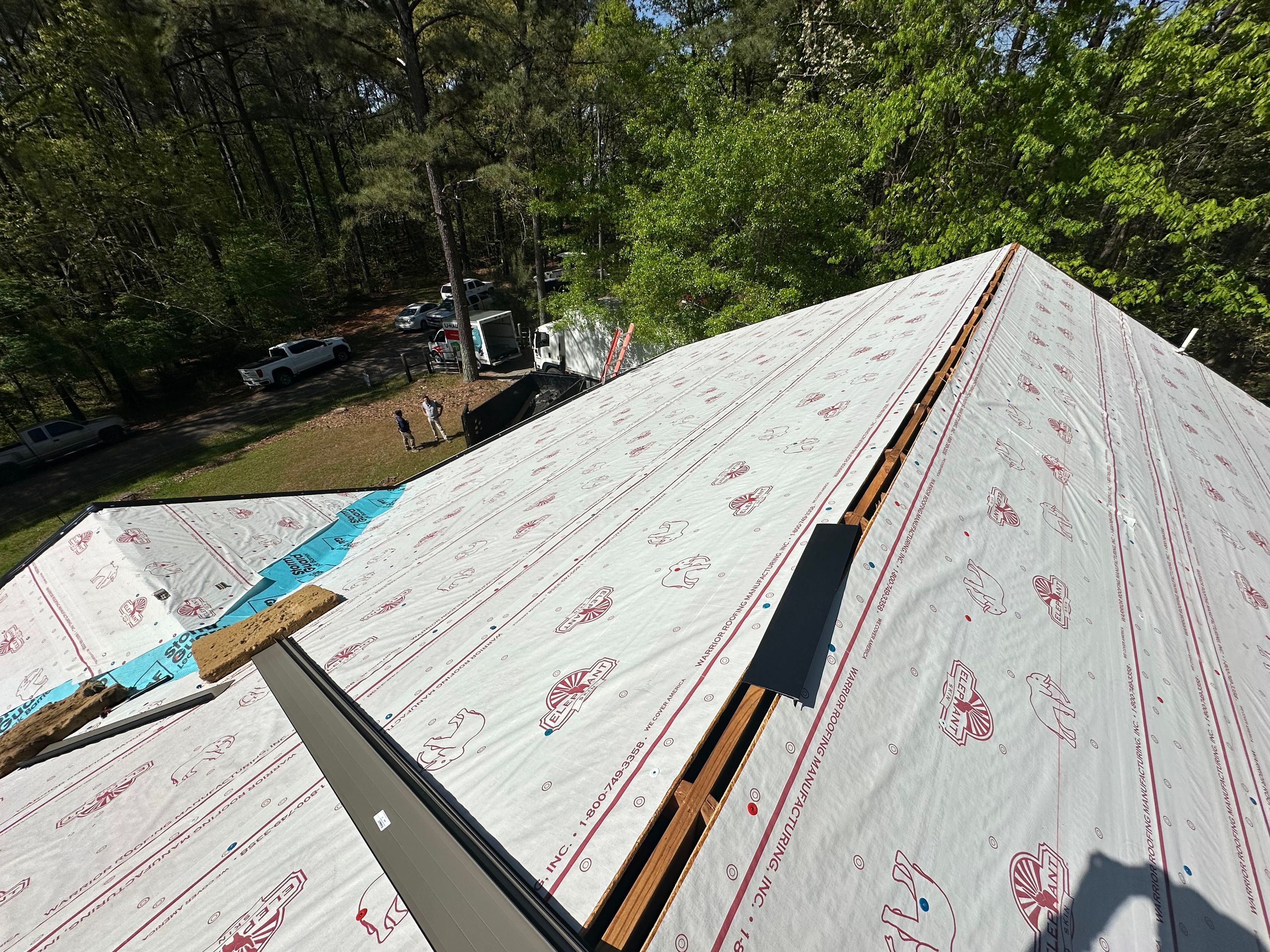 Roof replacement in Chelsea featuring newly installed underlayment and metal flashing on a residential pitch.