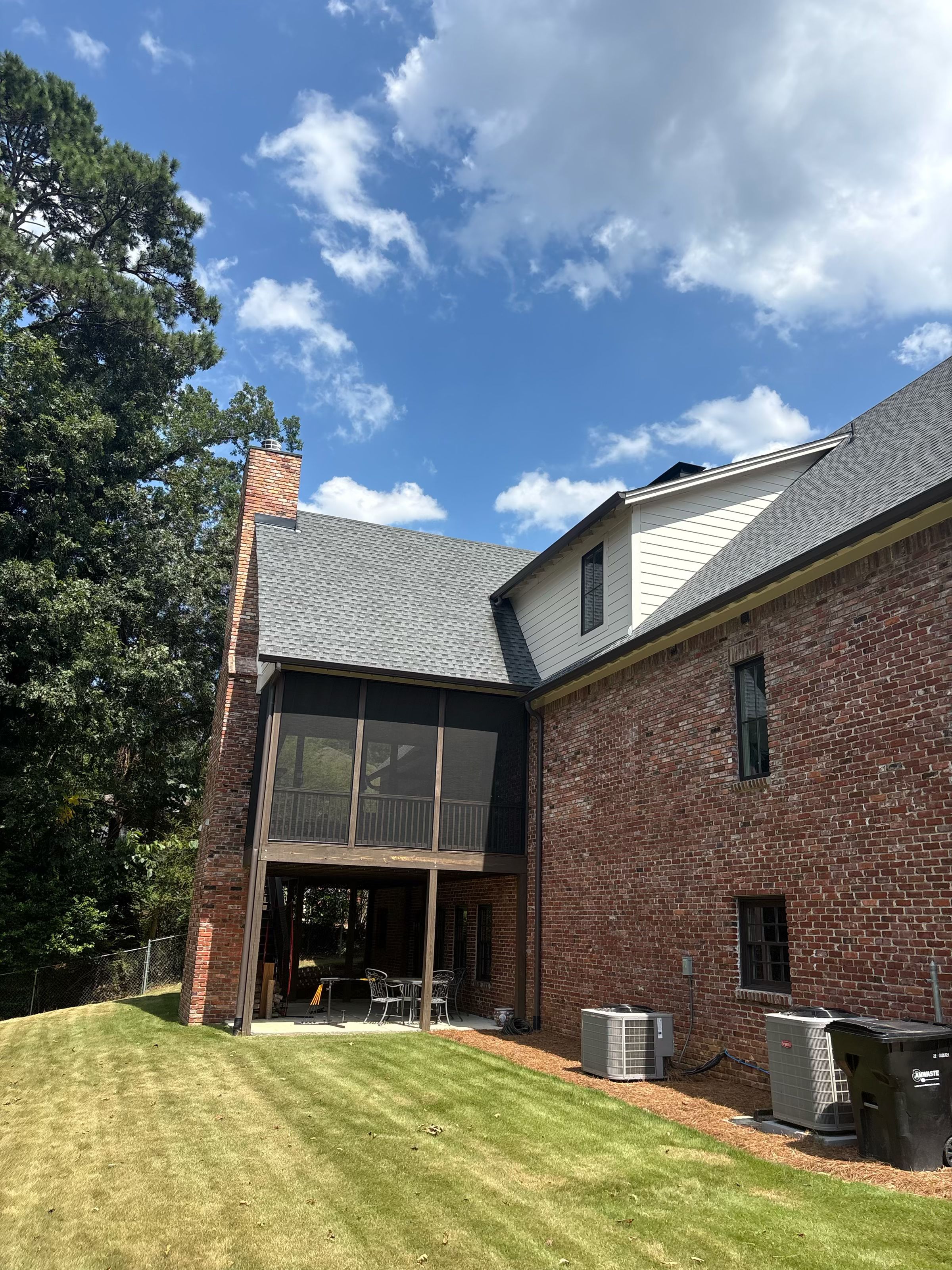 Gutter guards line the back roof above a screened porch on a brick home in Brookwood Forest, Mountain Brook.