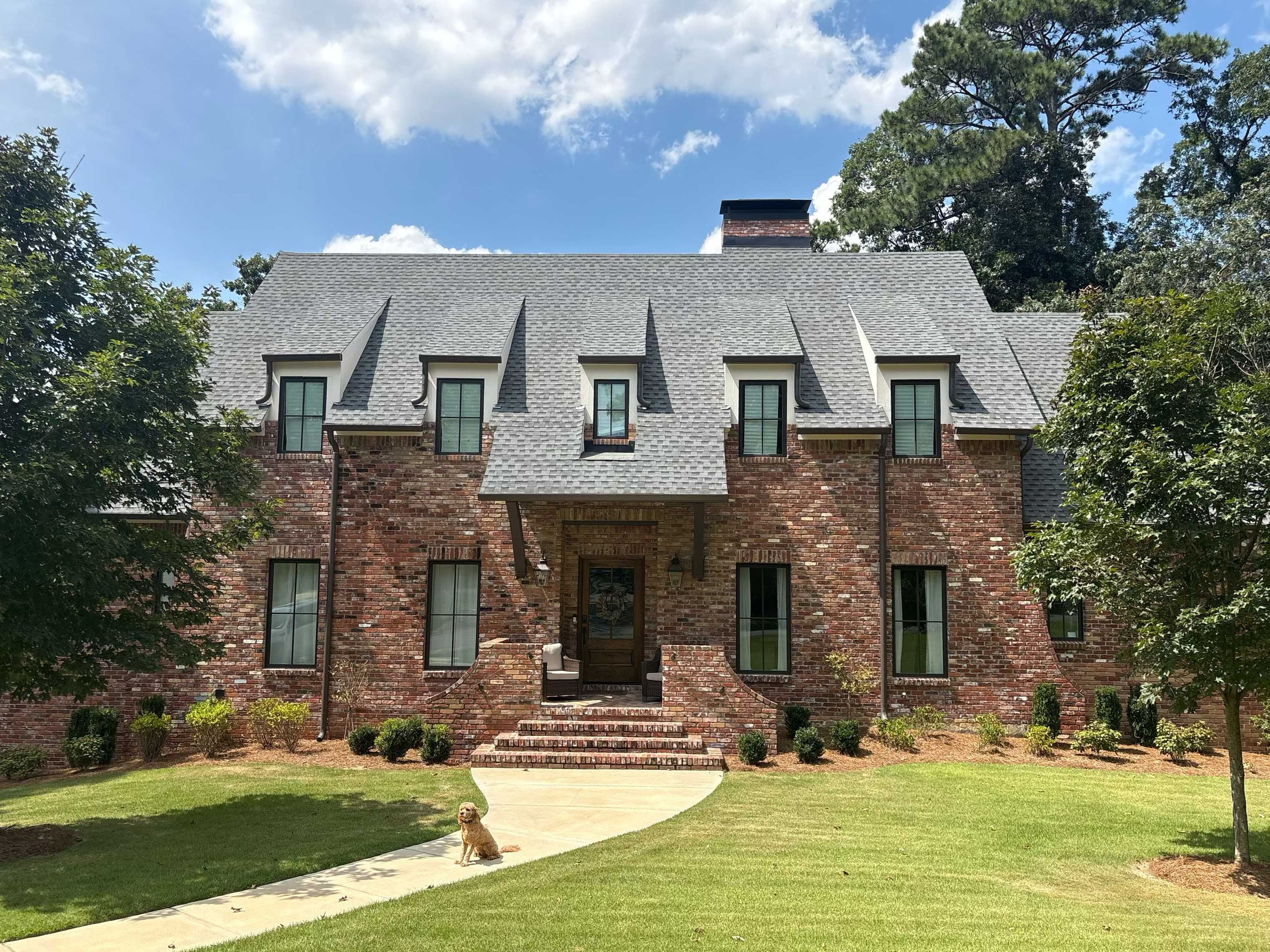 Protective gutter guards are installed on the dormer gutters above a brick front entrance.