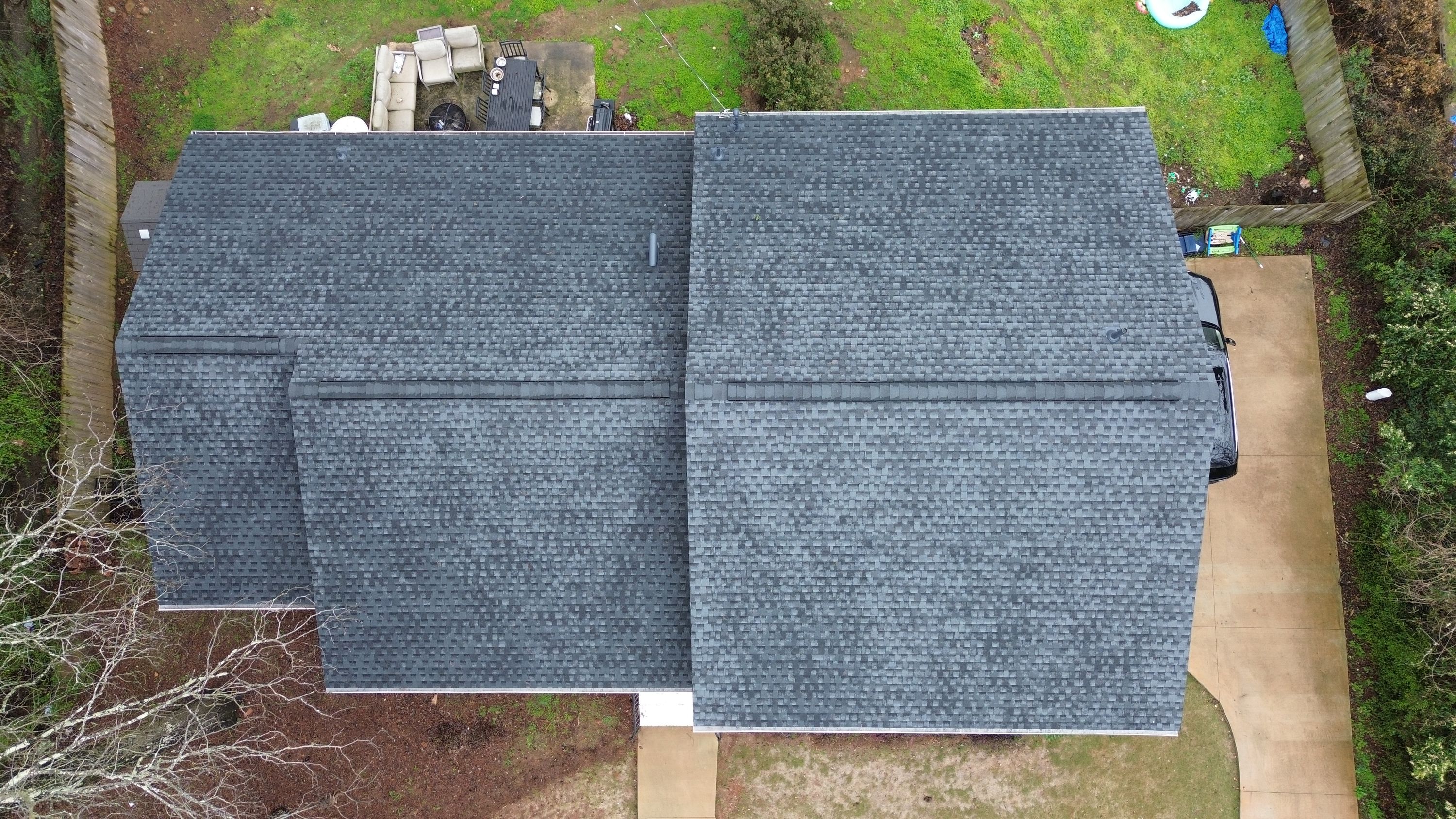 Aerial view of a newly completed gray shingle roof replacement on a home in Brookwood Forest, Mountain Brook.