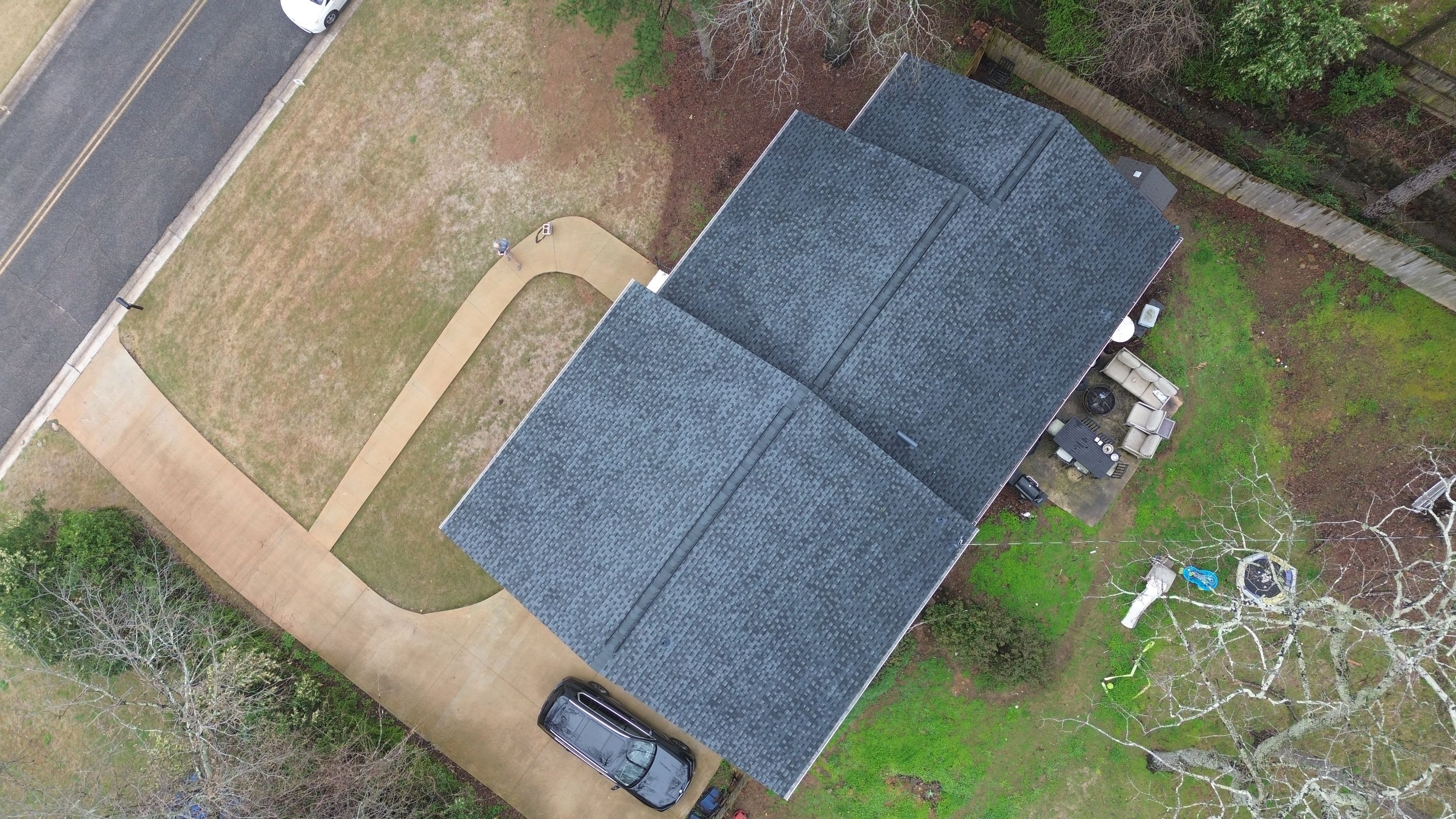 Aerial view of a completed roof replacement with dark grey shingles on a Mountain Brook home in Brookwood Forest.