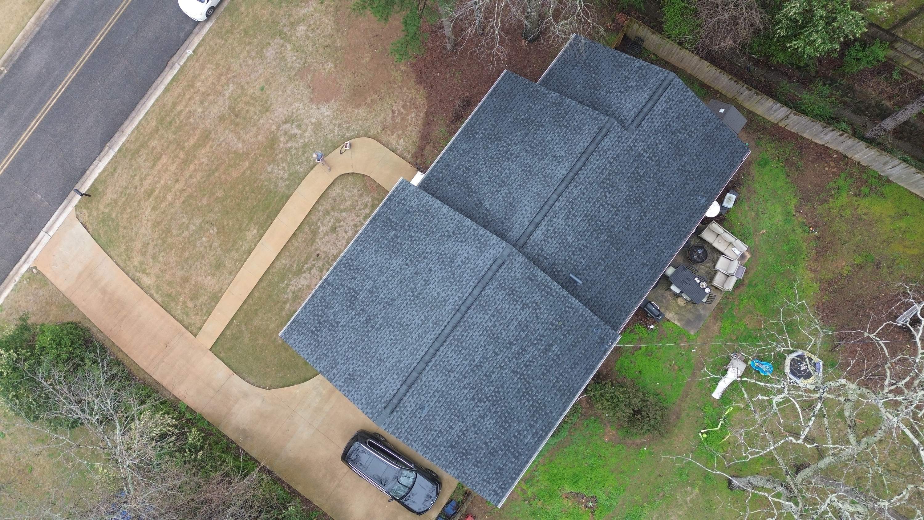 Aerial view of a completed roof replacement with dark grey shingles on a Mountain Brook home in Brookwood Forest.