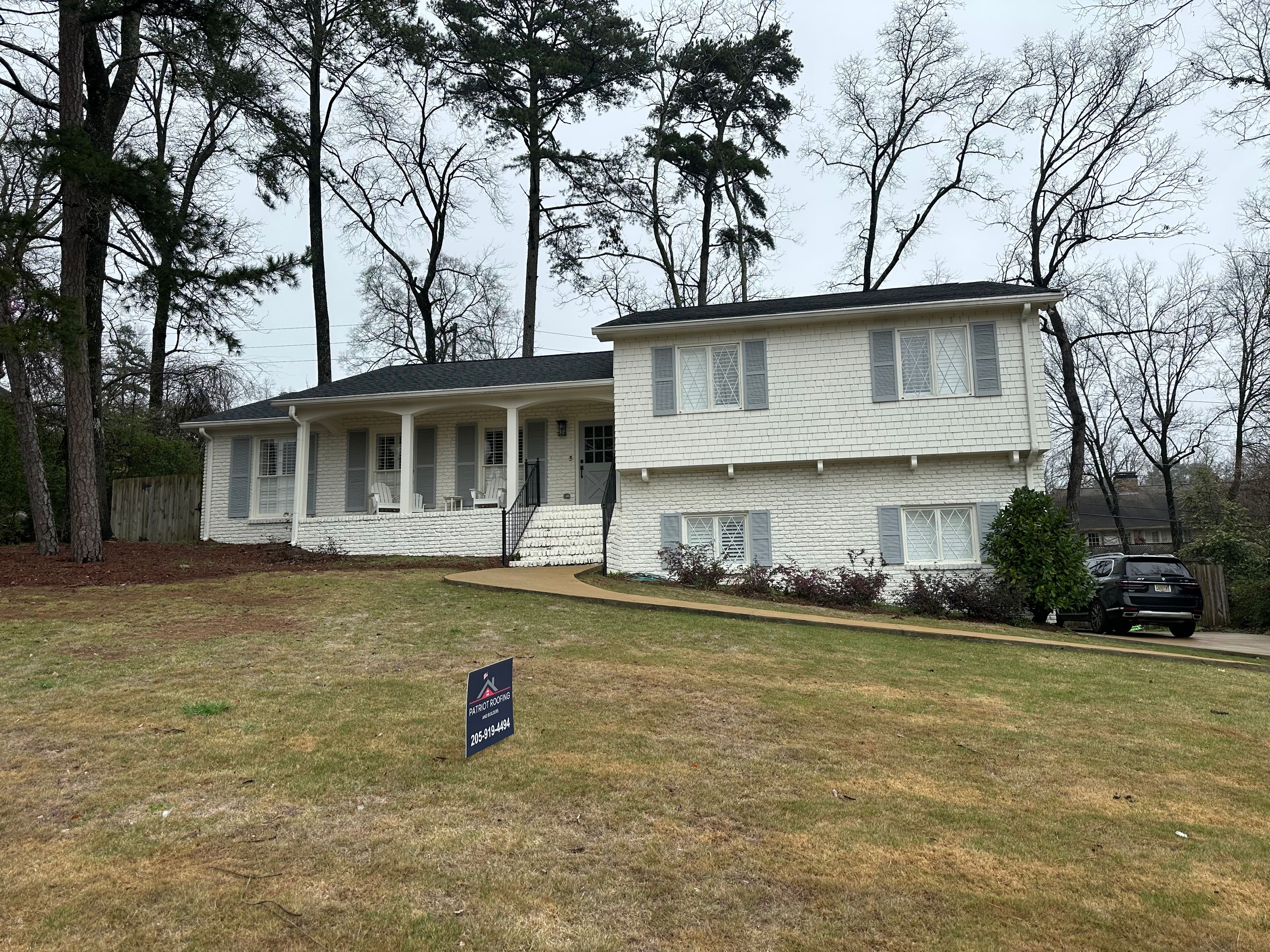 Completed roof replacement on a white brick and siding home in Brookwood Forest, Mountain Brook.