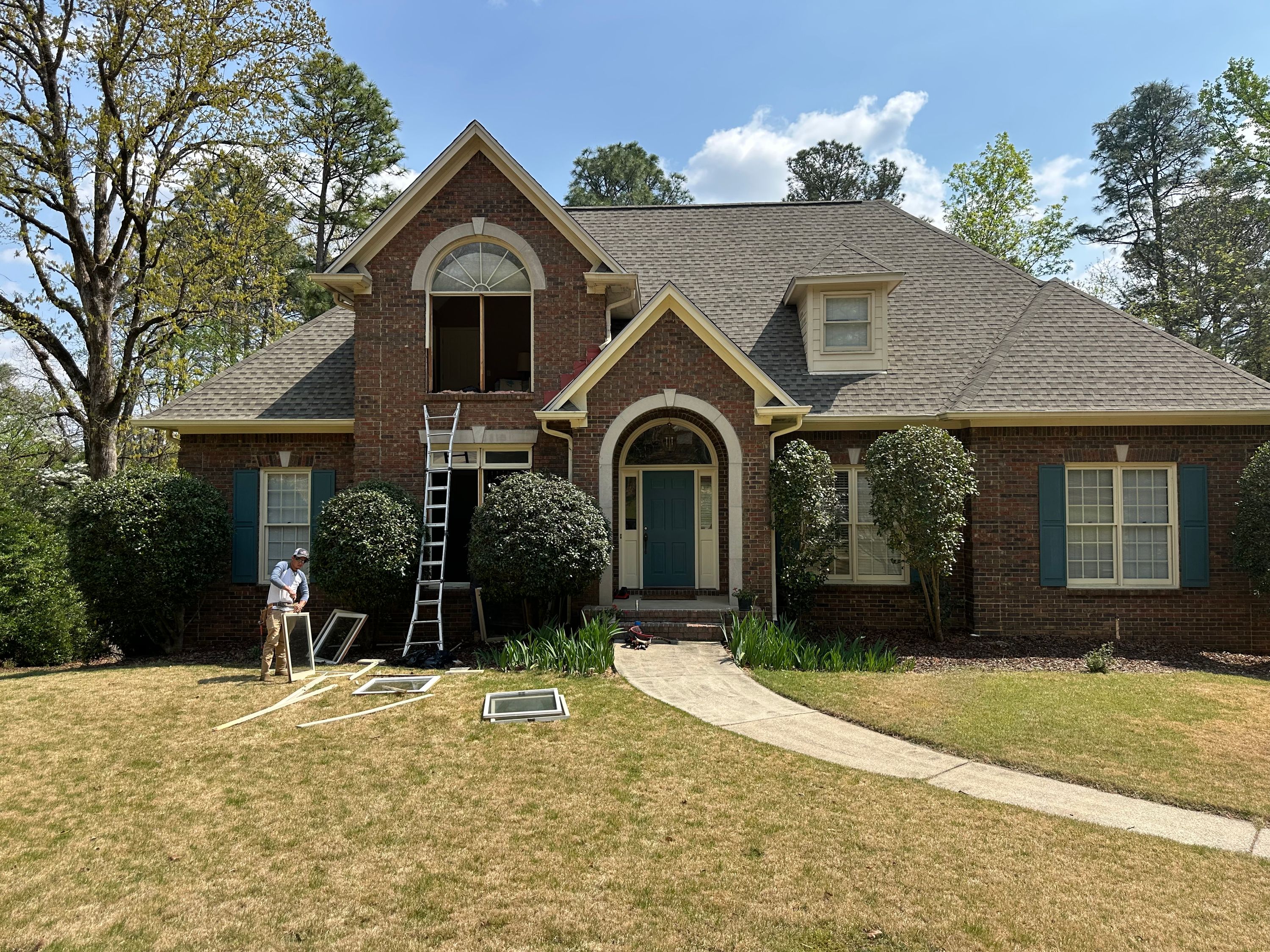 Patriot removes old window sashes during a second-story window replacement at a brick home in Hoover.