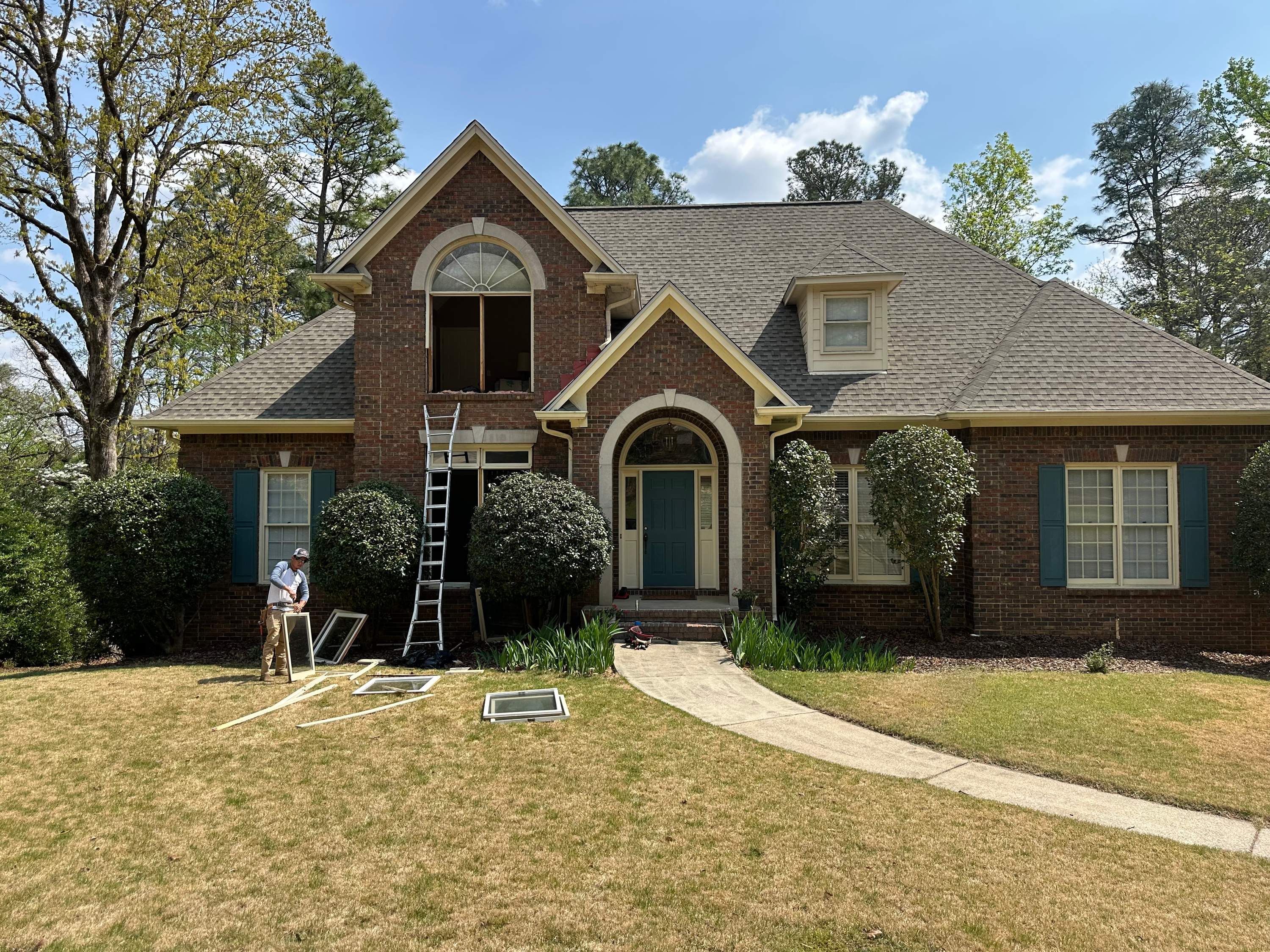 Patriot removes old window sashes during a second-story window replacement at a brick home in Hoover.