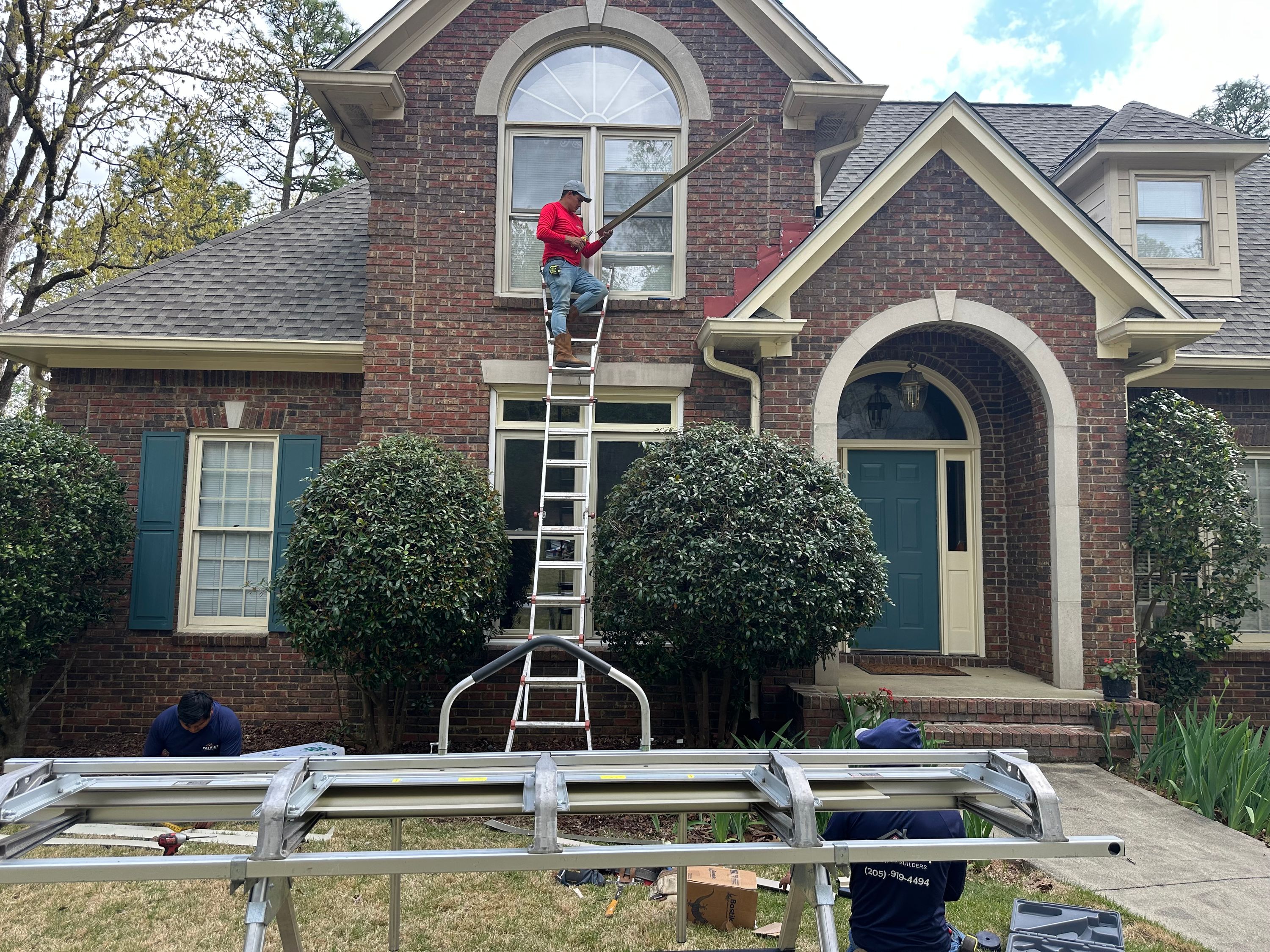 Patriot Roofing and Builders crew uses an aluminum brake and extension ladder for window replacement  in Hoover.
