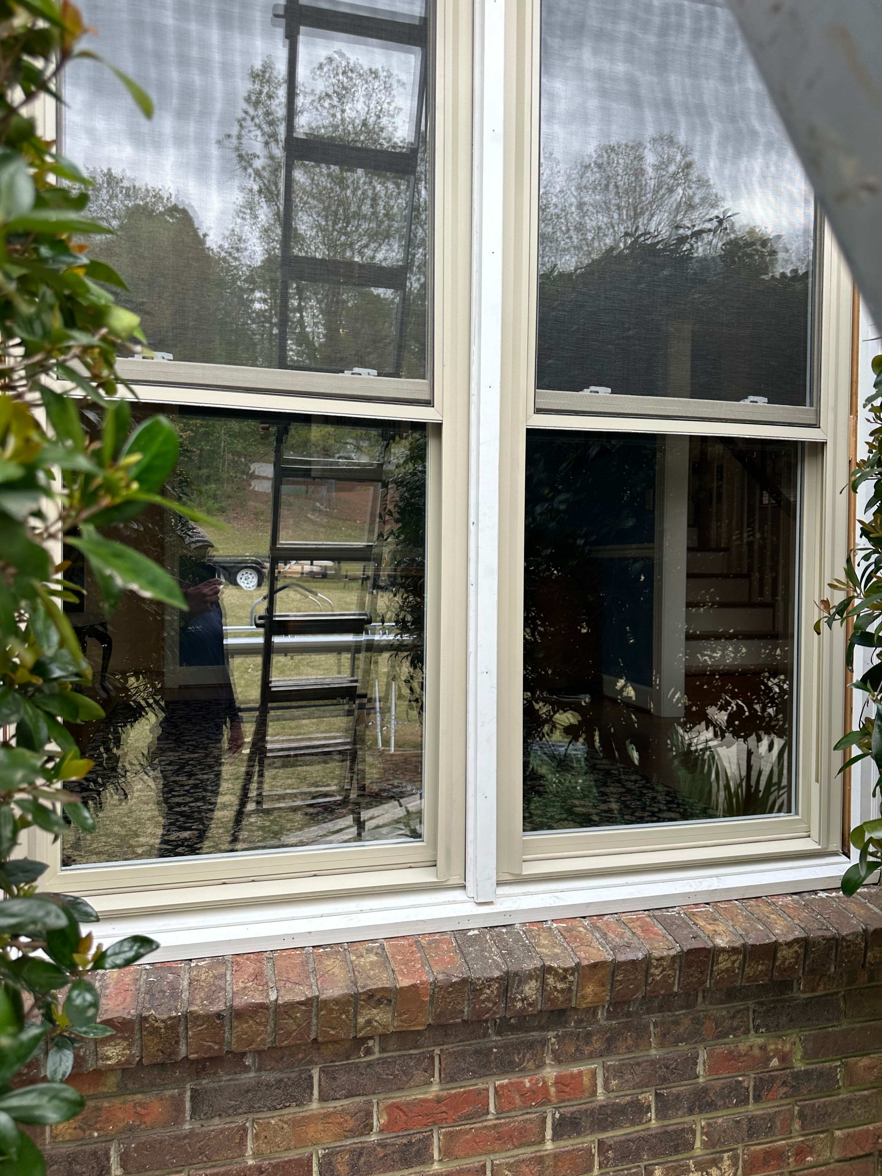 Patriot Roofing and Builders installed this new double-hung window with screens over a brick sill in Hoover.