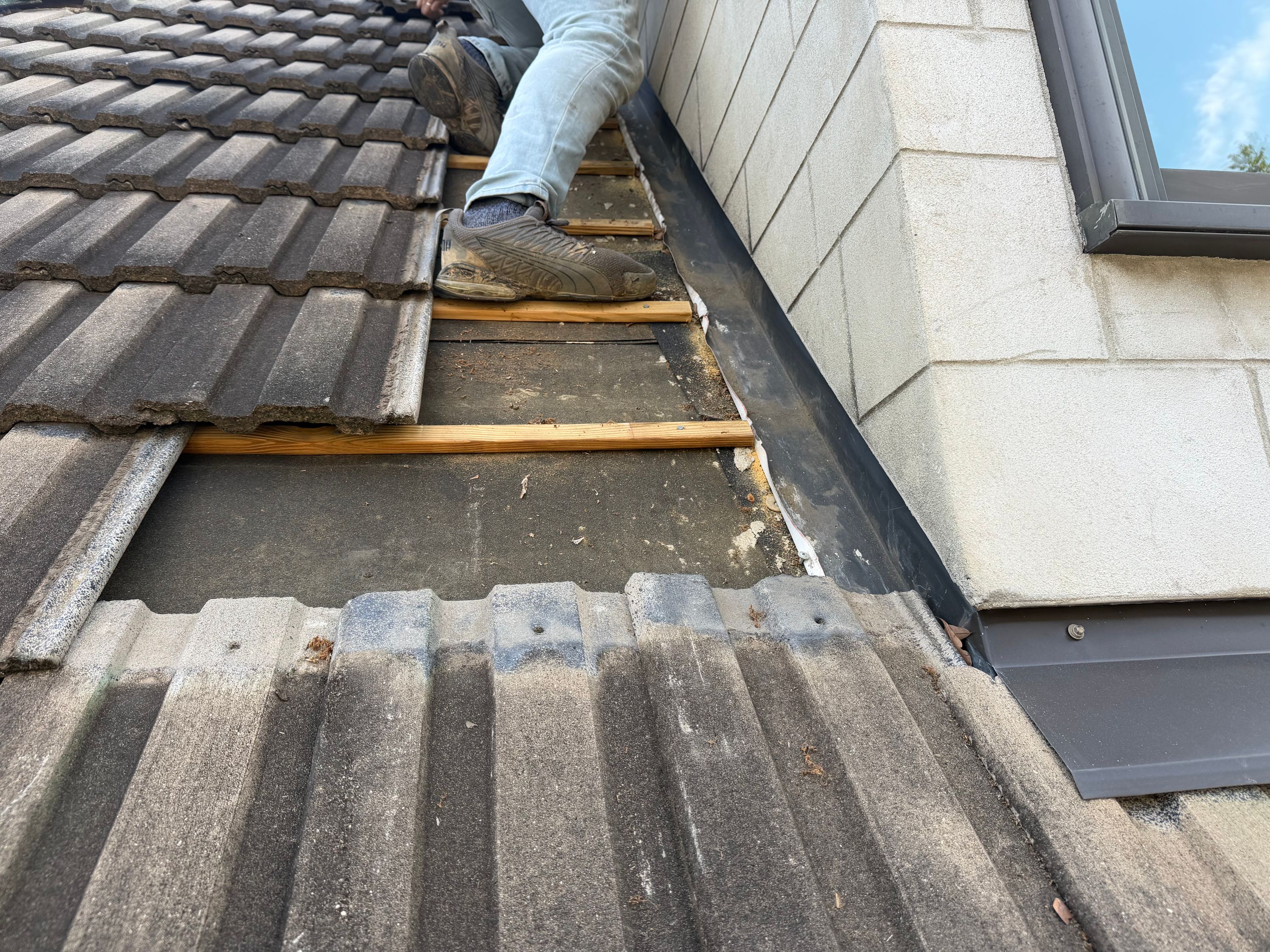 Exposed wood battens and wall flashing shown during roof repair in Forest Park.