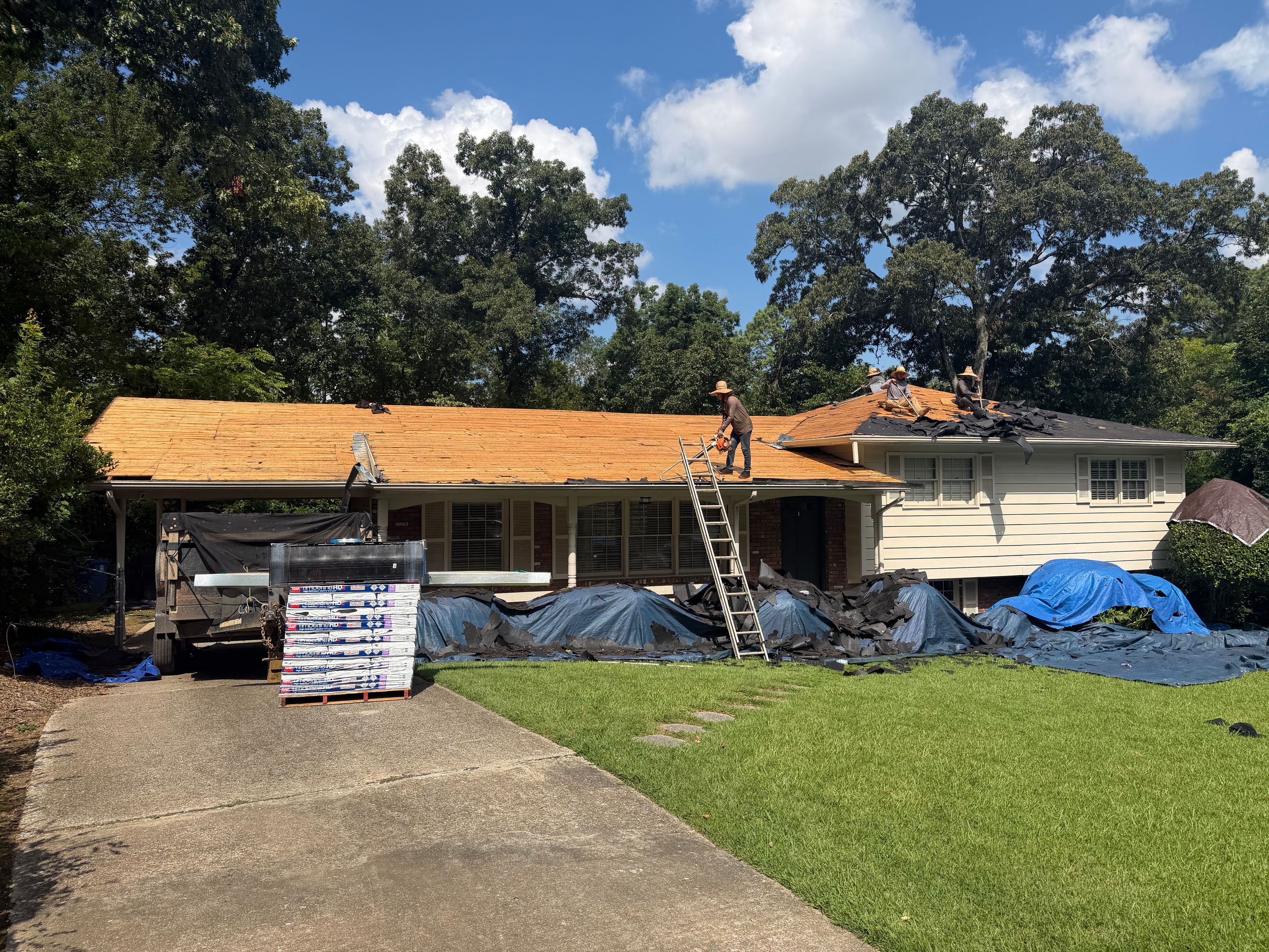 A utility ladder stands ready during a home roof replacement and gutter installation in Birmingham.