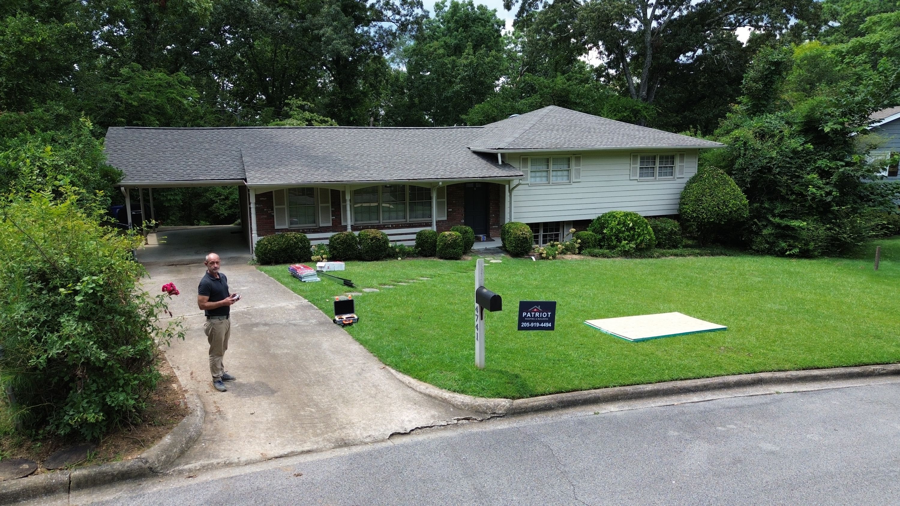 Freshly installed grey shingles line the eaves and valleys above a landscaped front yard.