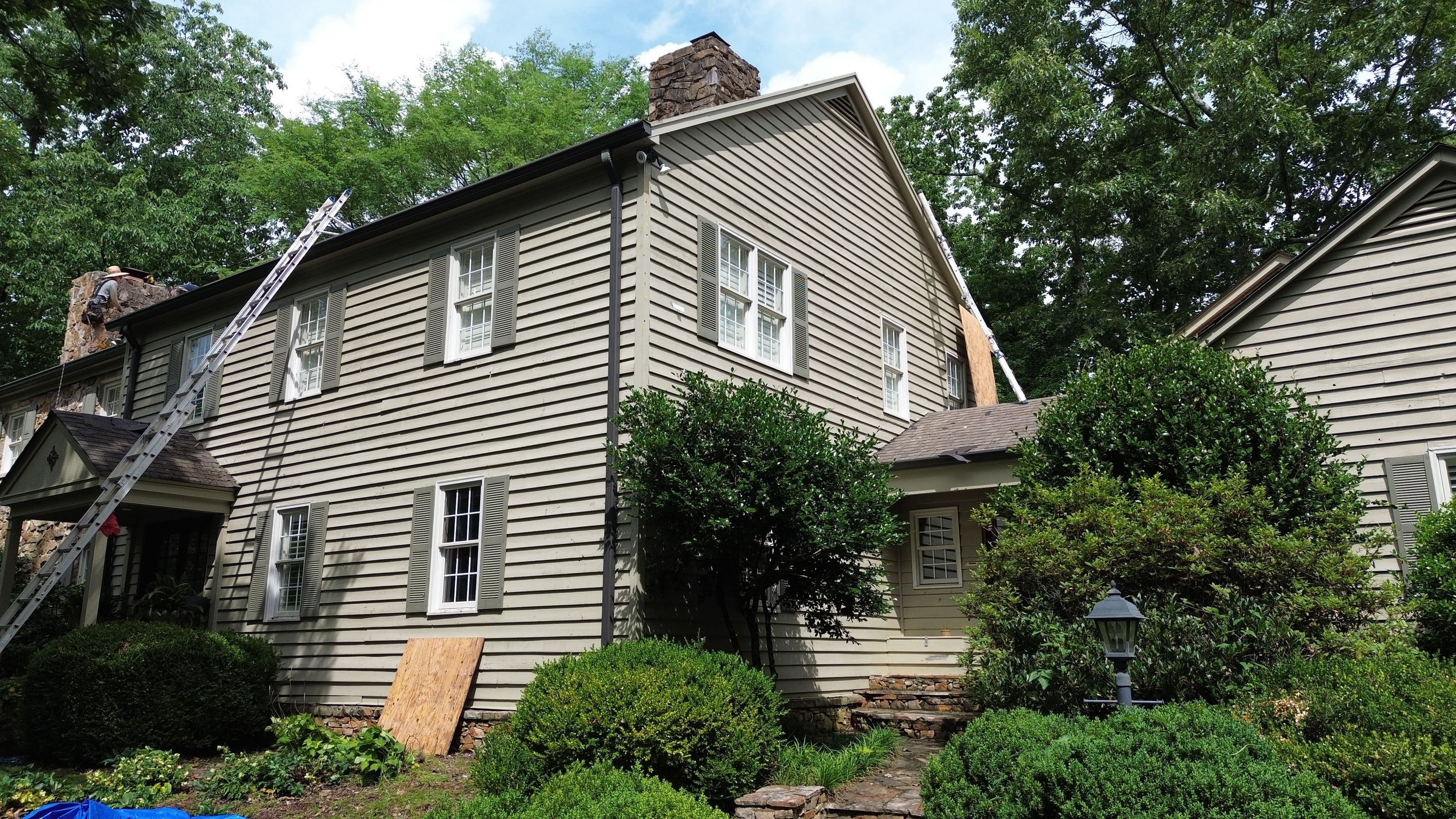 A home undergoing a residential roof replacement in Mountain Brook with ladders set up.