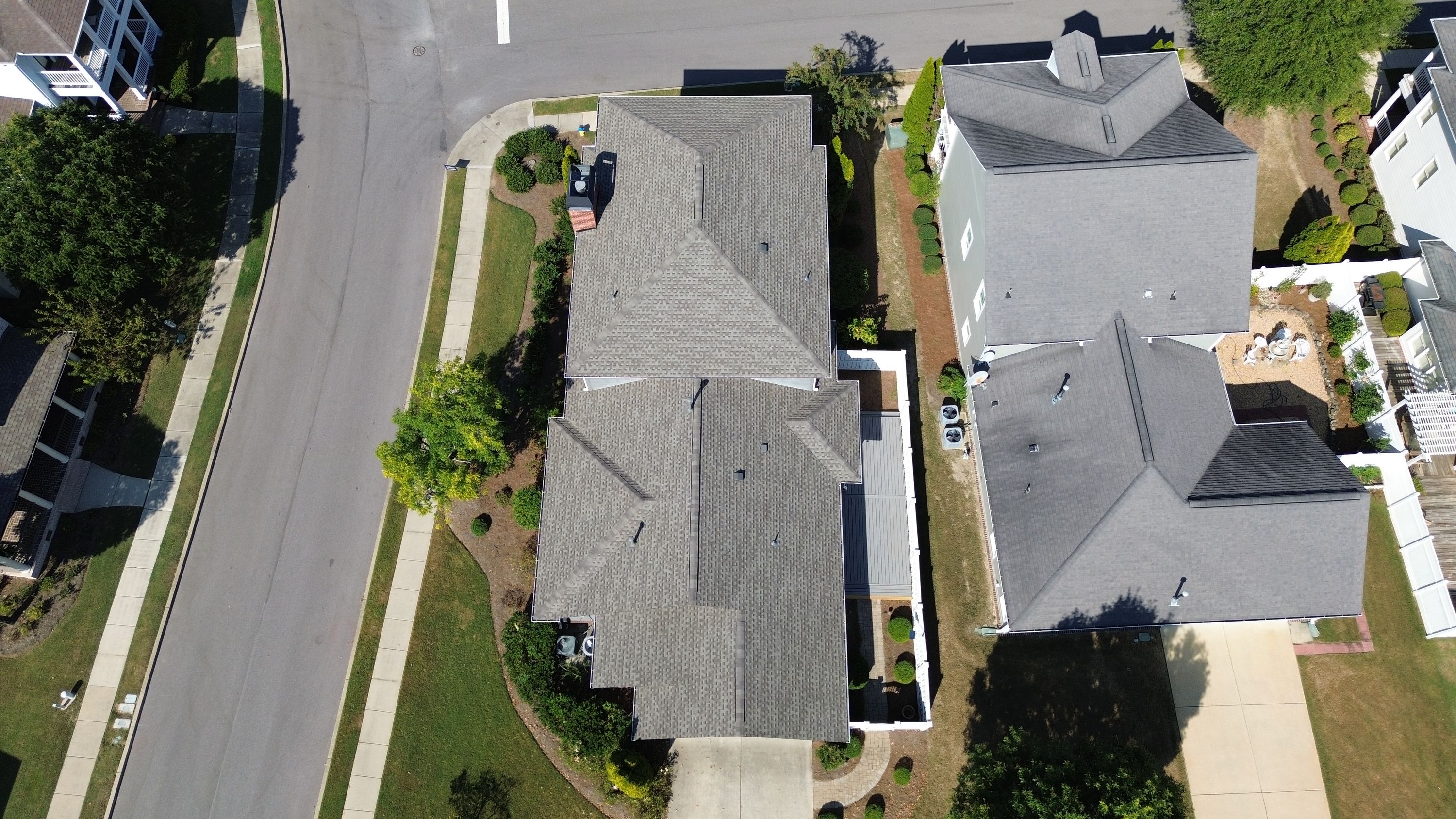 An overhead aerial view shows the completed roof replacement featuring clean grey shingles and white gutters.
