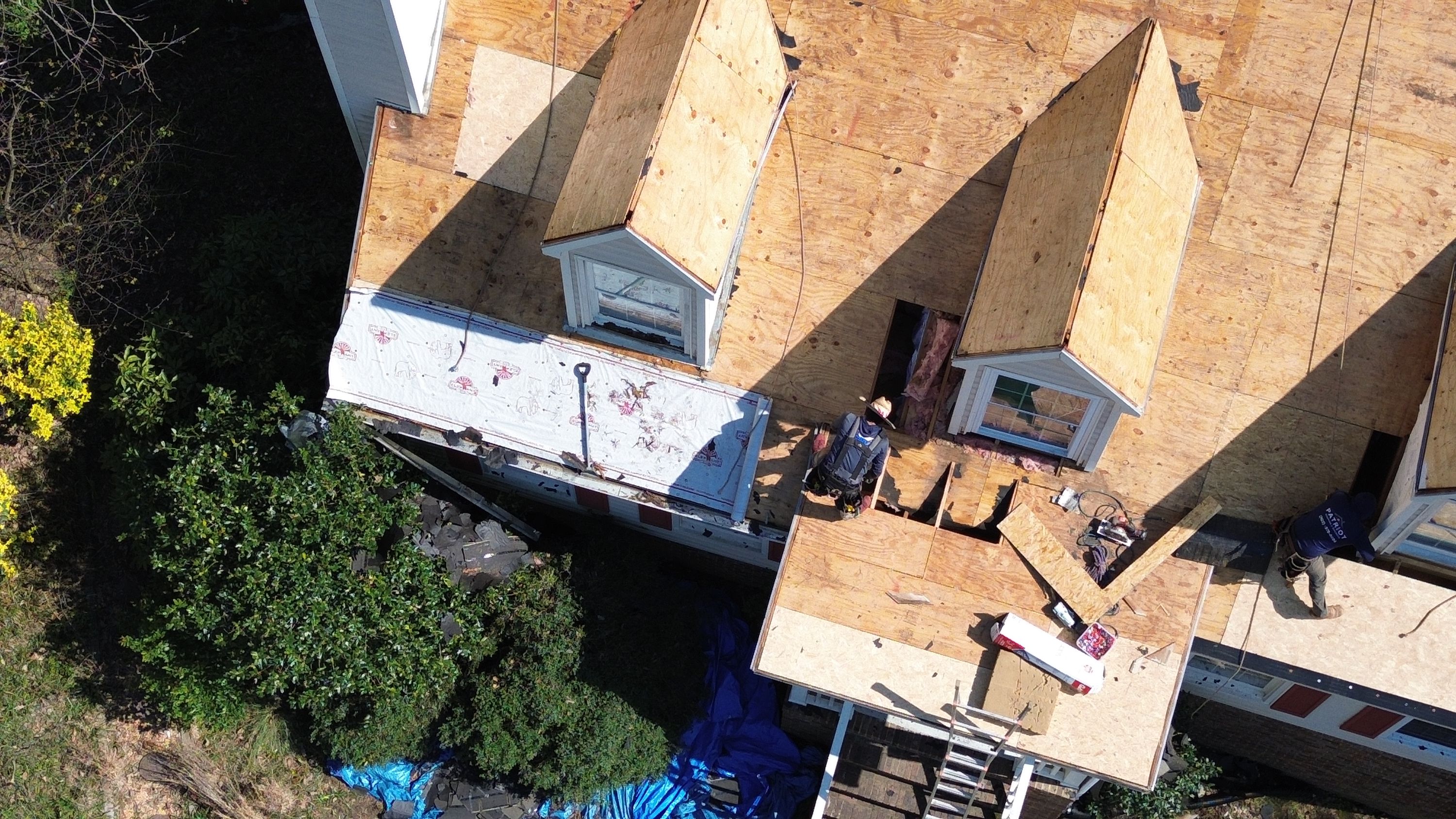 Aerial view of contractors performing a roof replacement on a home in Hoover's Bluff Park neighborhood.