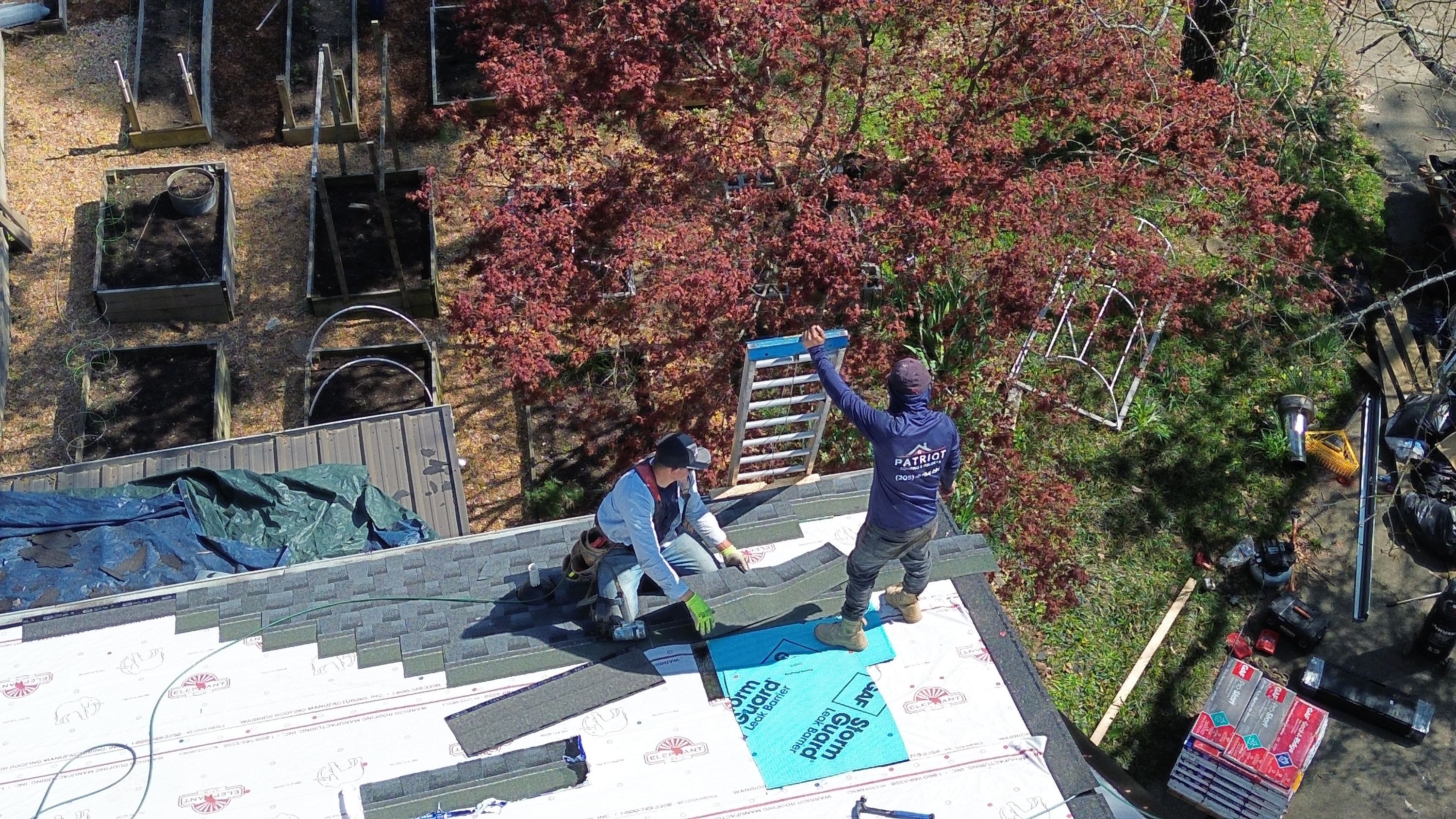 Contractors installing asphalt shingles for a roof replacement project in the Bluff Park neighborhood of Hoover.
