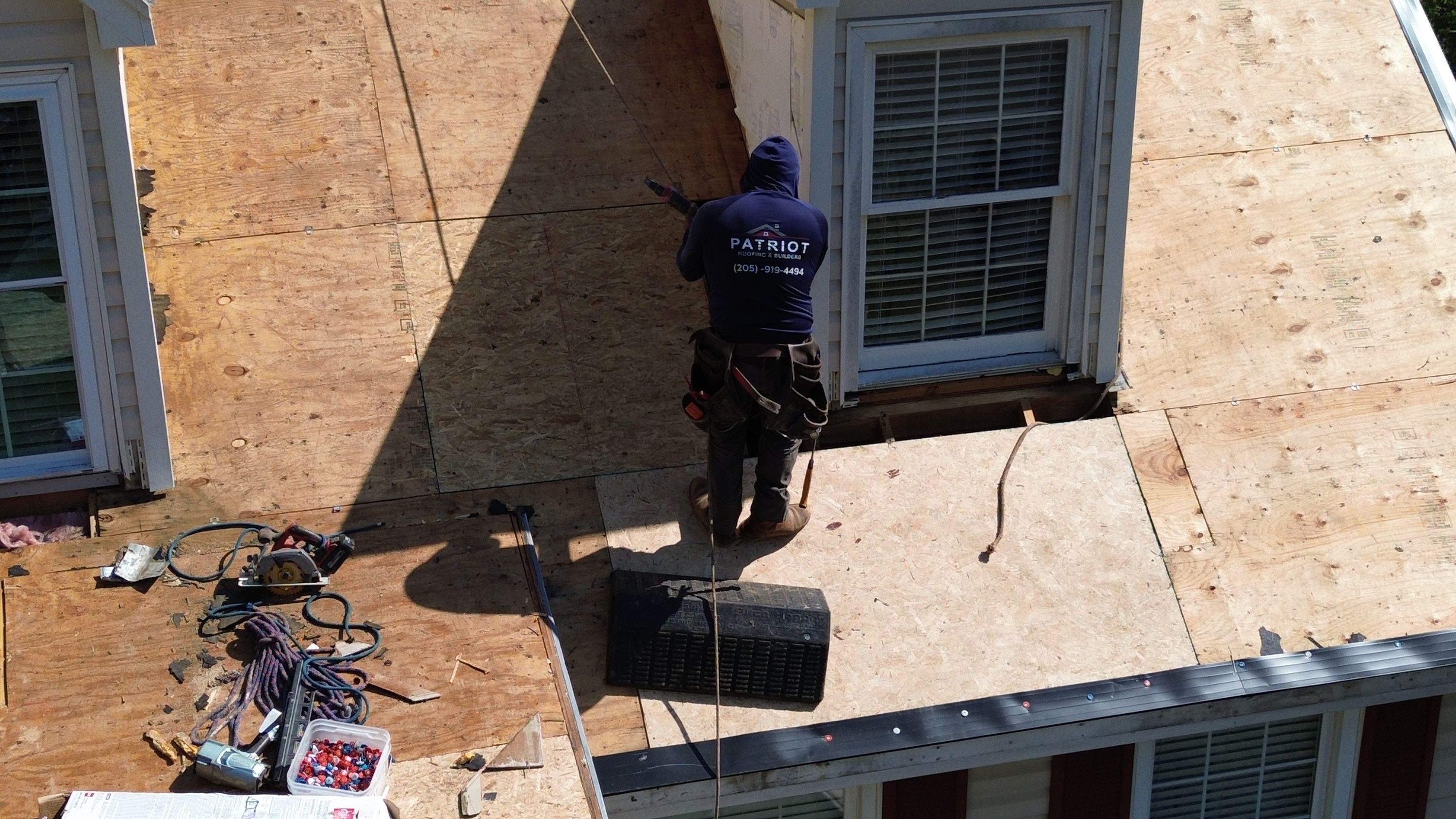 Roofing professional installing plywood decking during a residential roof replacement project in Hoover, Alabama.