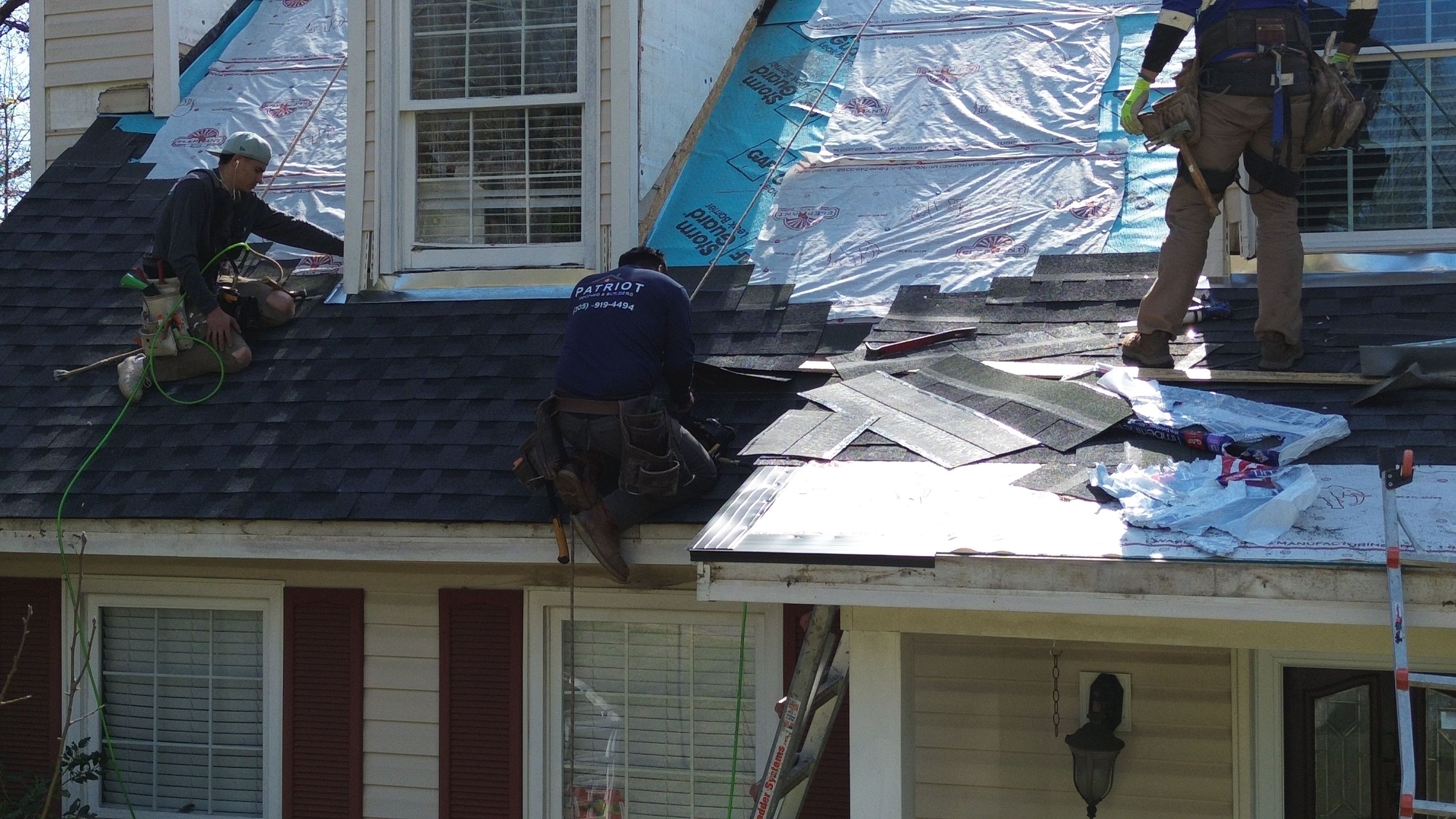 Patriot Roofing and Builders crew installs asphalt shingles over synthetic underlayment on a Bluff Park home.