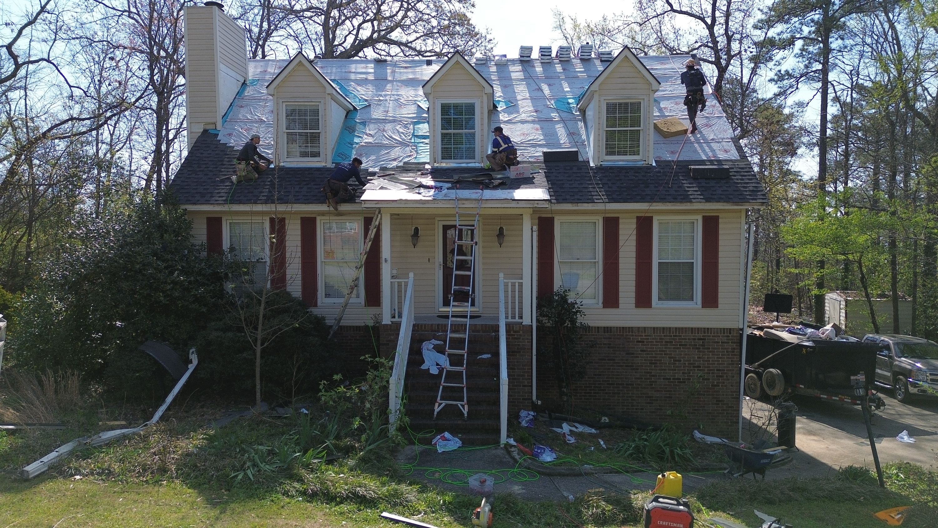 Patriot Roofing and Builders crew installs synthetic underlayment during a roof replacement in Bluff Park.