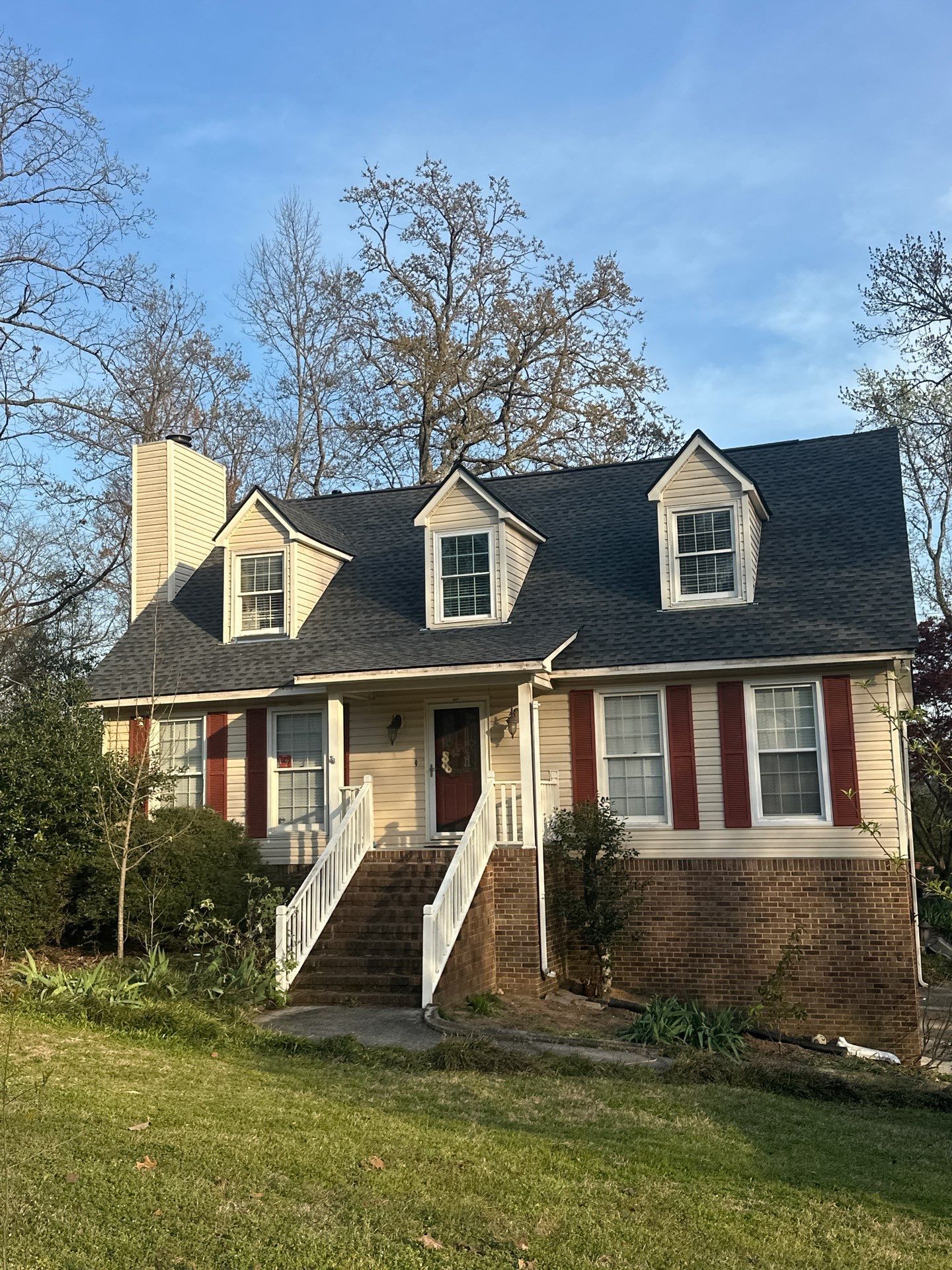A house in Bluff Park featuring a completed roof replacement with new dark shingles and white windows.
