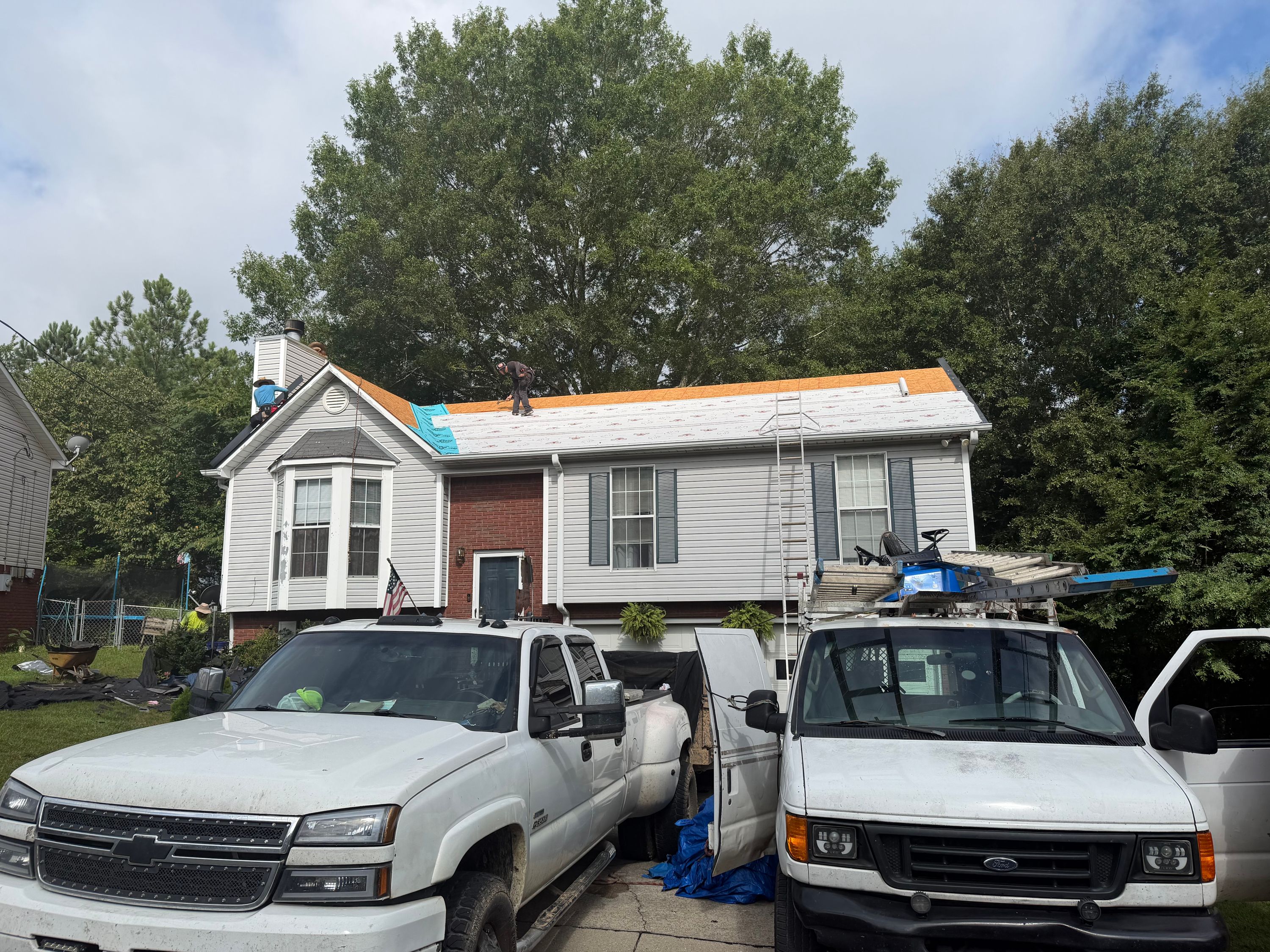 New synthetic underlayment is installed on a home's roof deck during a Birmingham roof replacement.