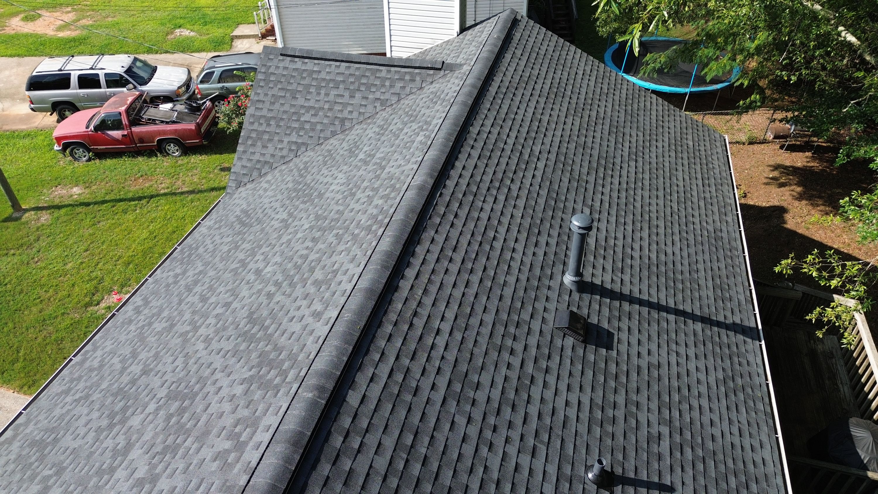 Ridge cap shingles run straight down the hip of this completed residential roof.