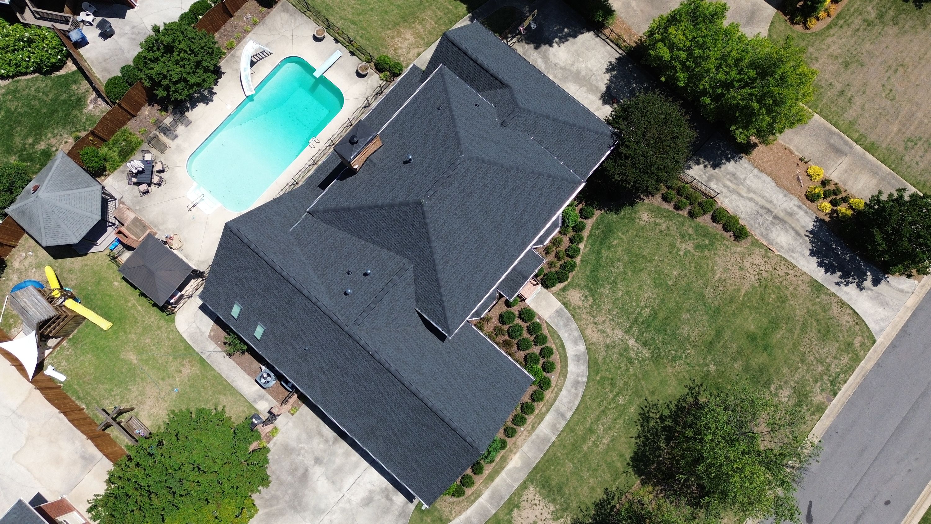 An aerial view of a newly installed dark asphalt shingle roof on a house in the Carisbrooke neighborhood of Hoover.