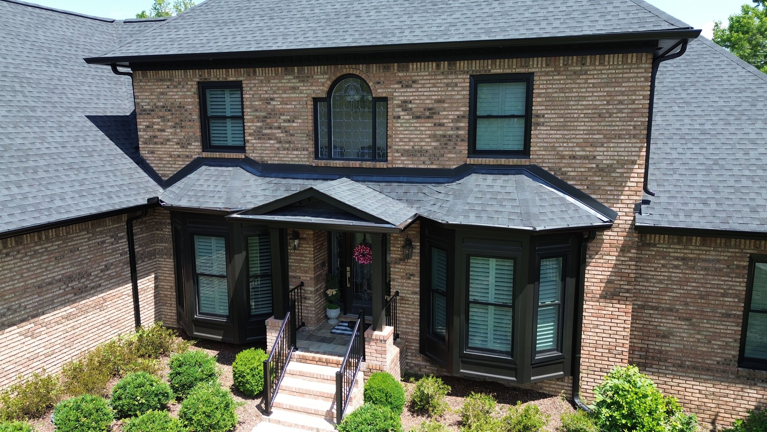 A house in Carisbrooke, Hoover features a new asphalt shingle roof, black window frames, and matching gutters.