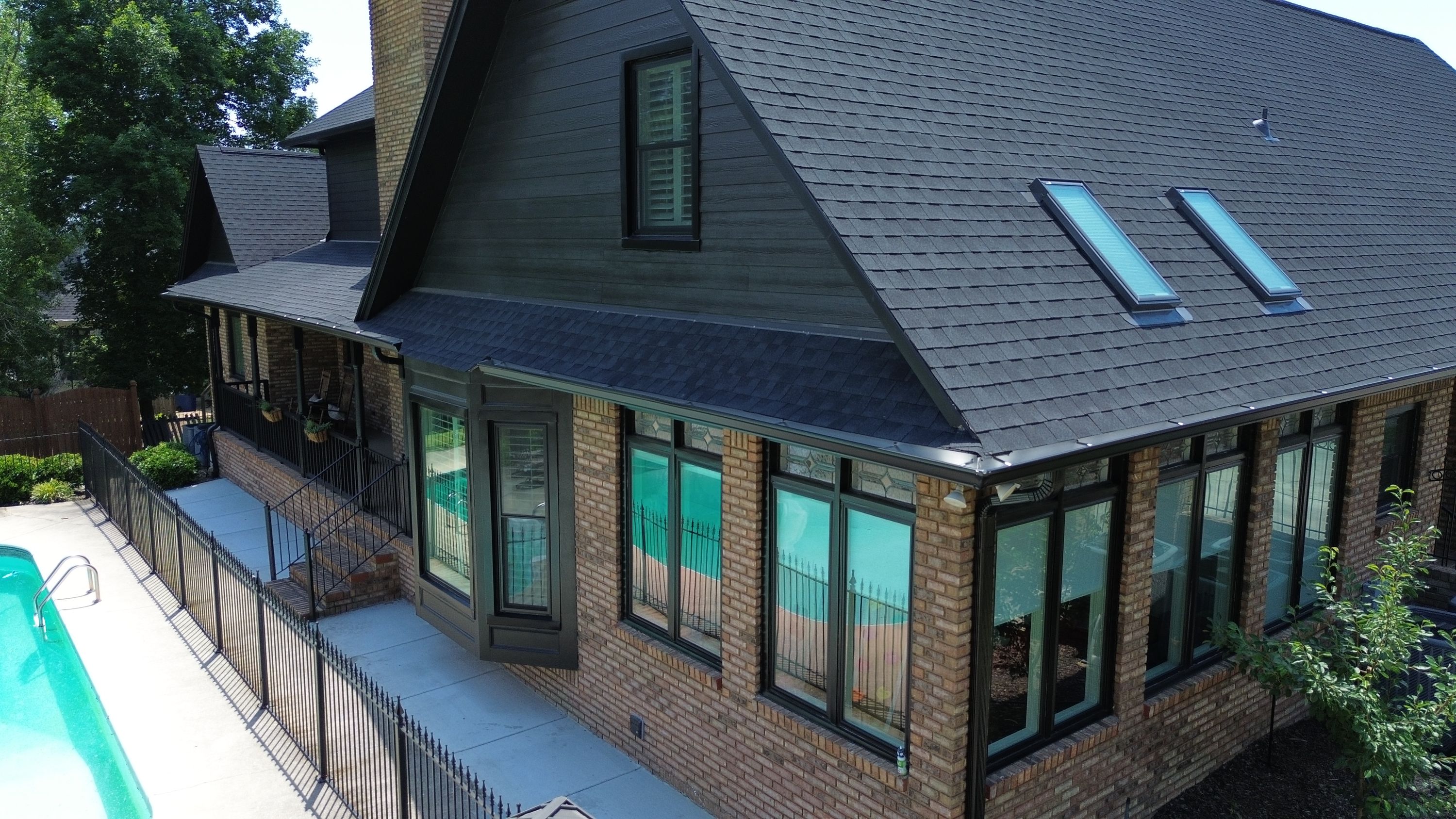 A house in Carisbrooke, Hoover featuring a completed roof replacement, new gutters, and dark window trim.