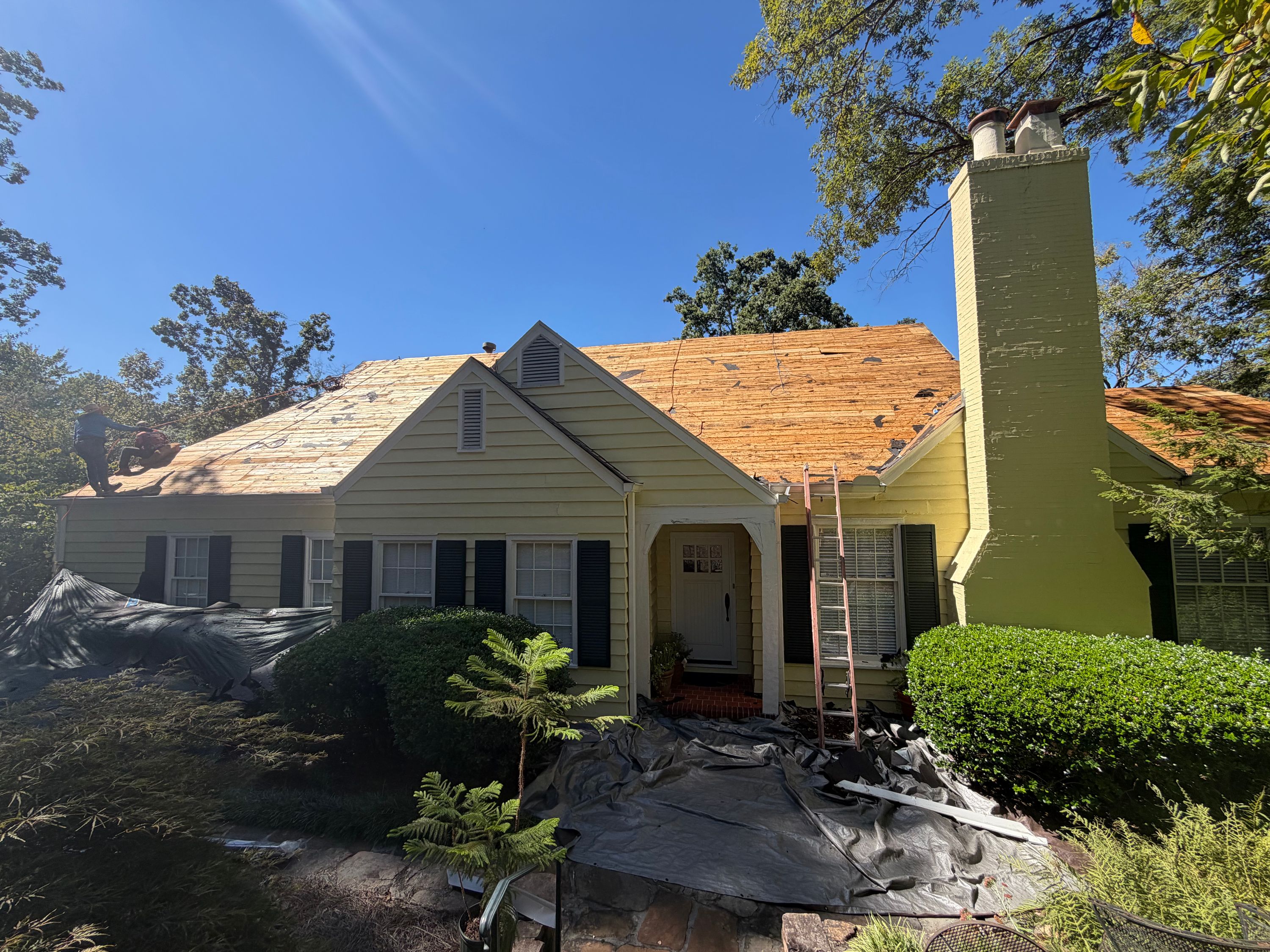 Tarps protect a Mountain Brook Village home's porch during the tear-off phase of a roof replacement.