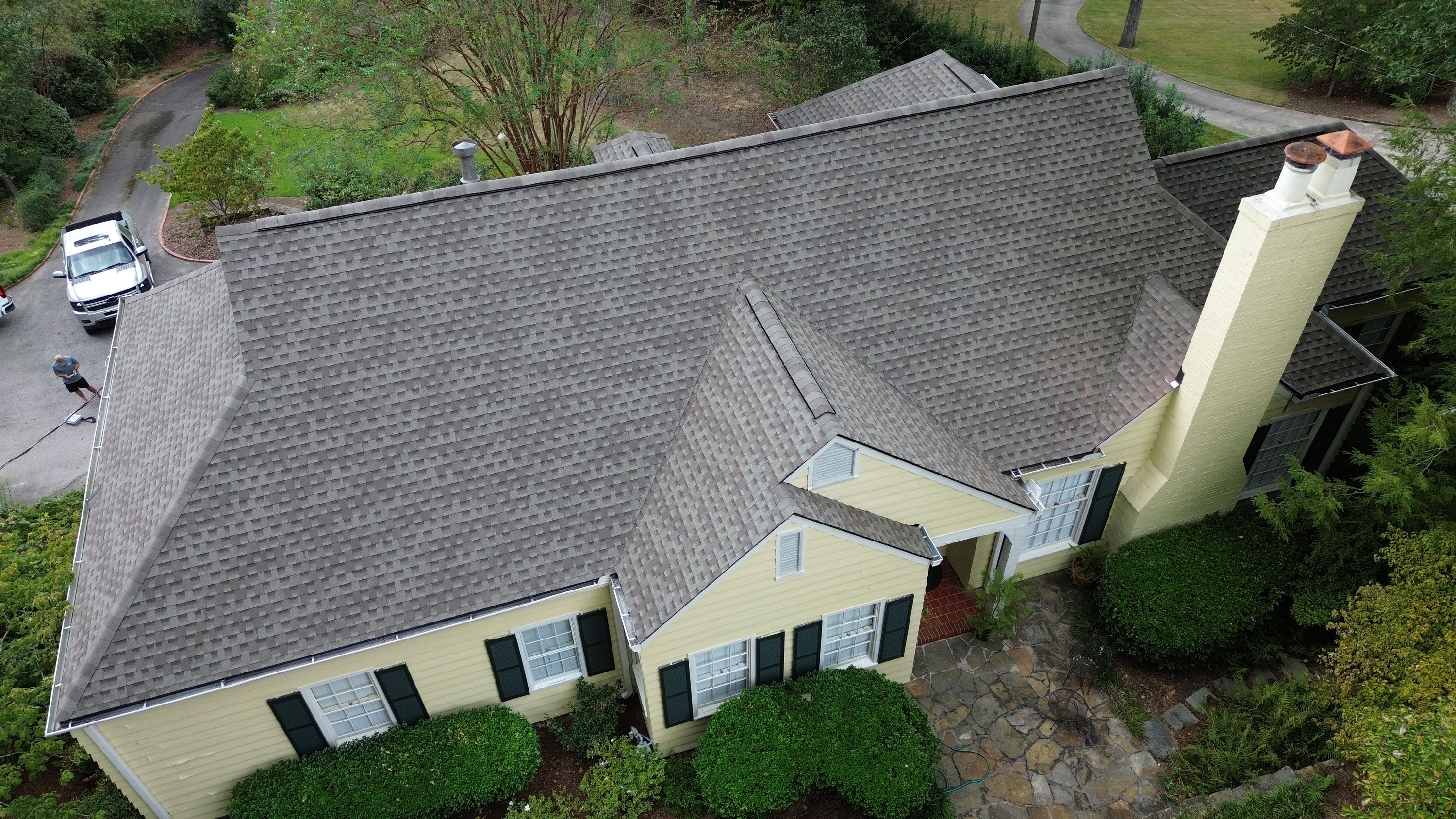 Clean ridge vents line the peaks of interlocking shingle roofing sections above green shutters.