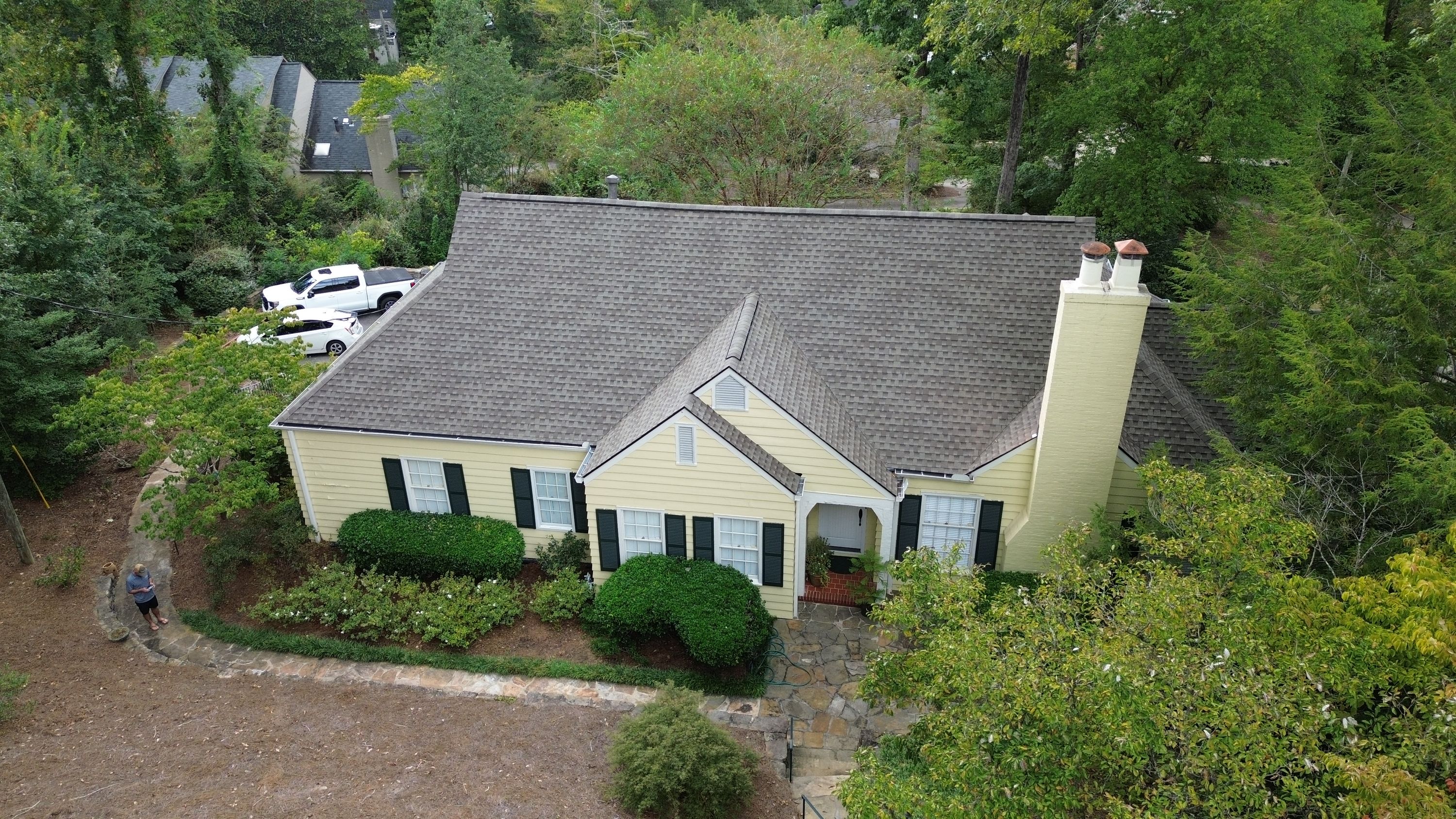 New grey shingles cover the steep gables above a stone entryway on Overhill Road.