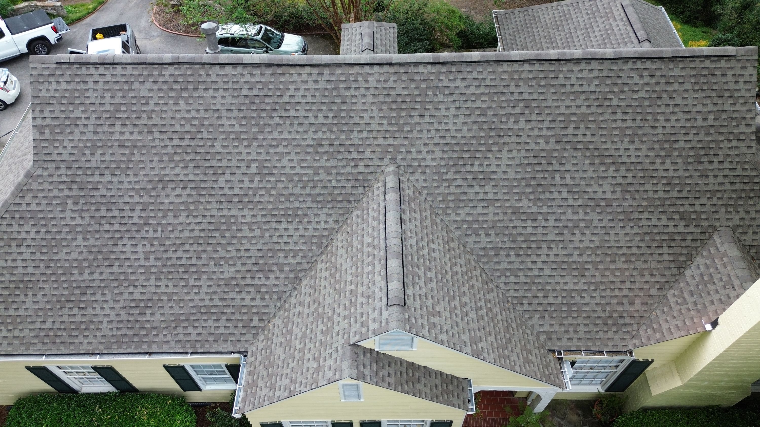 A top-down perspective highlights a straight ridge vent installed along the main roof peak.