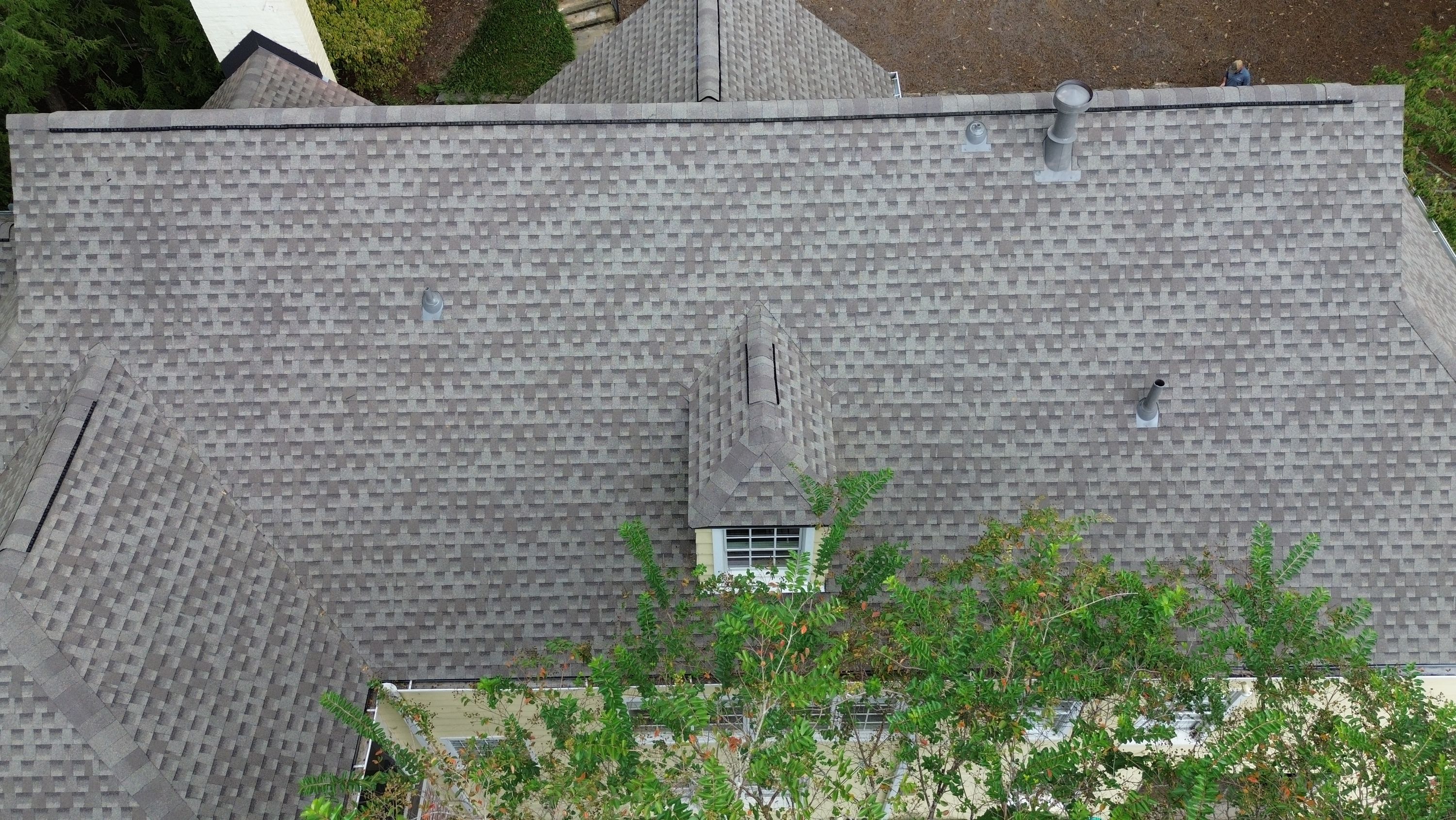 Overhead view of a completed shingle roofing installation on a small dormer window.