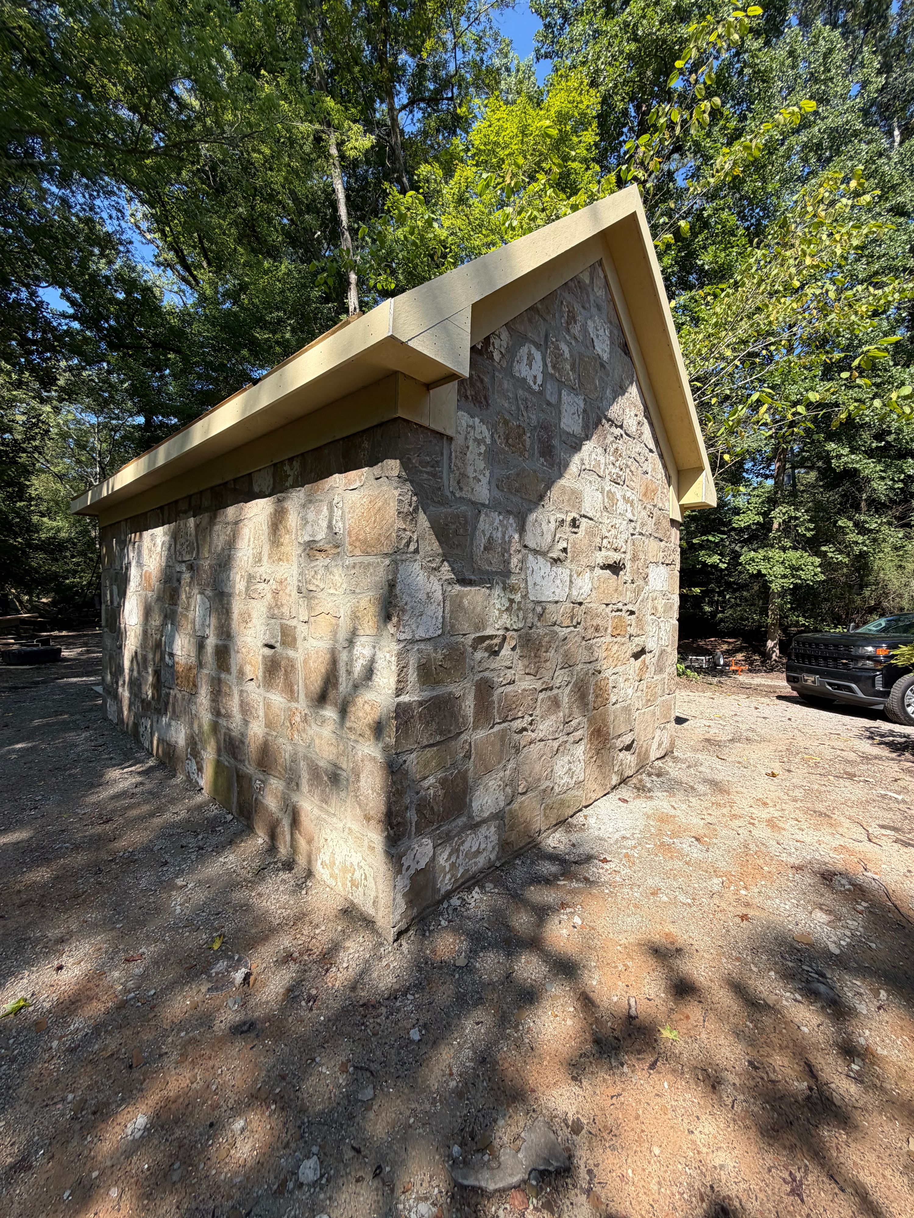 Rear corner of the reclaimed stone corn shed on a wooded lot along the Cahaba River