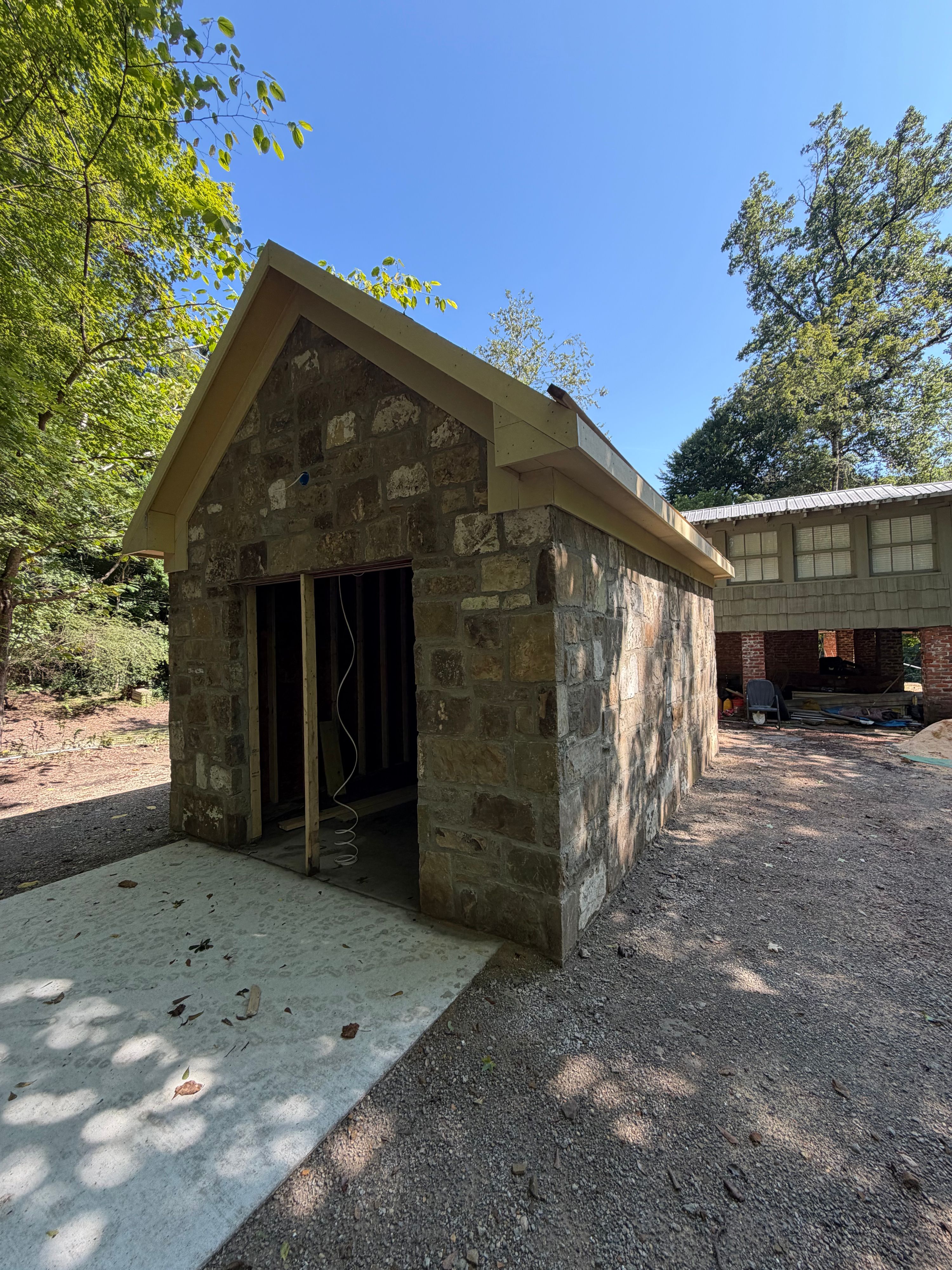 Front corner of the corn shed showing the framed doorway and reclaimed stone masonry