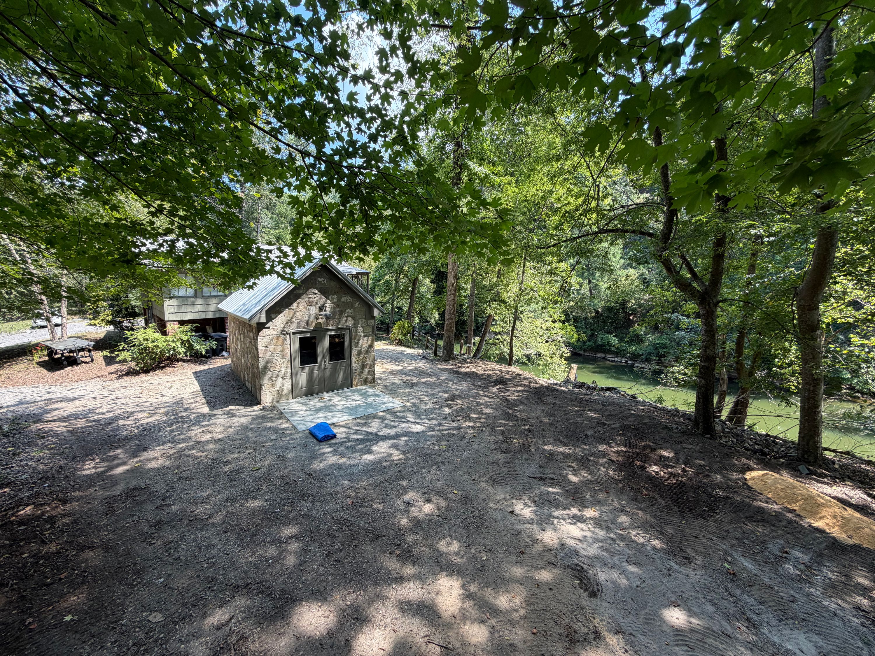 Wooded property along Old Looney Mill Rd in Vestavia Hills features a cleared path next to the stone structure.