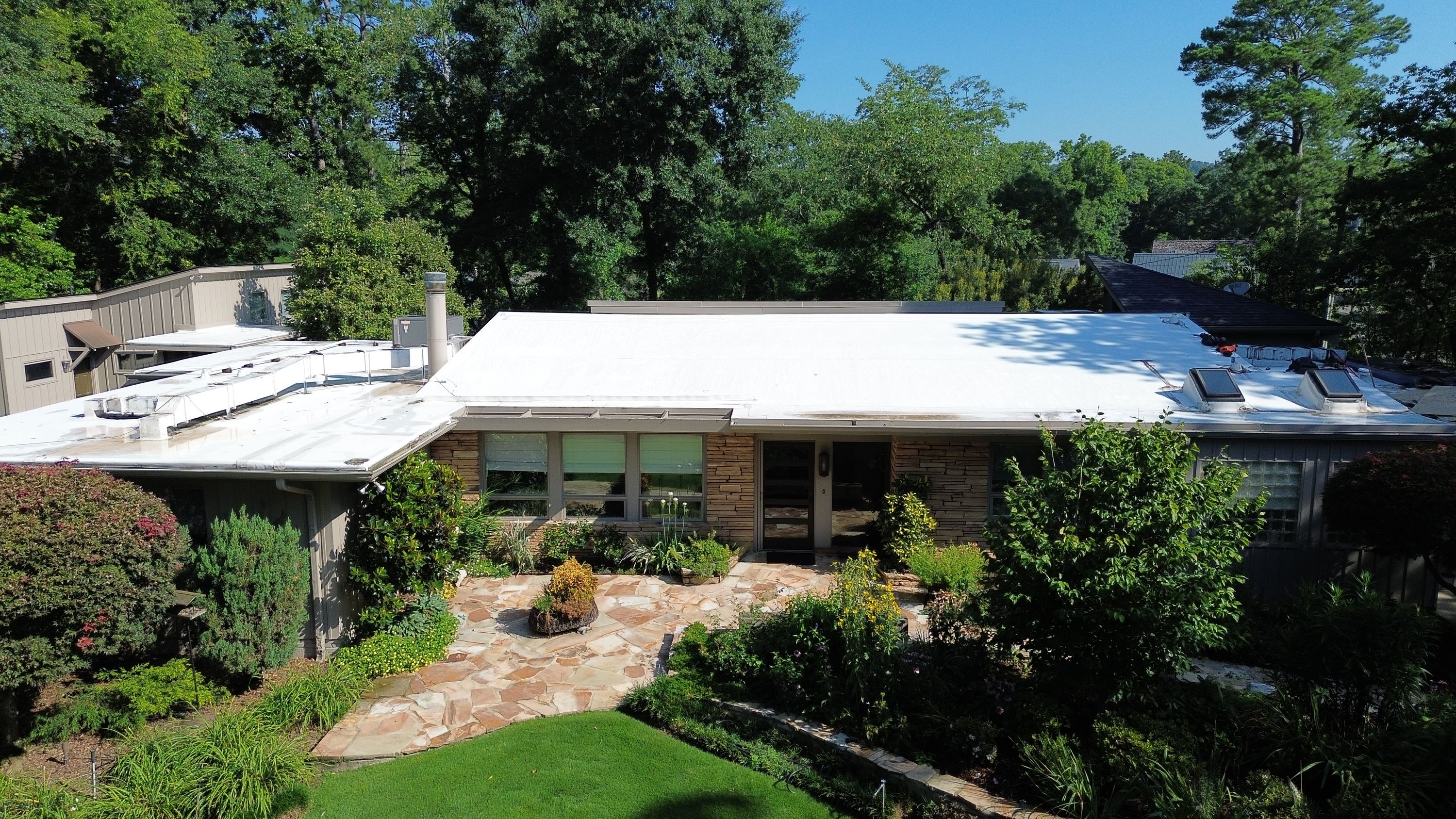 A clean white flat roof edge stands out above the stone facade of this Crestline home.