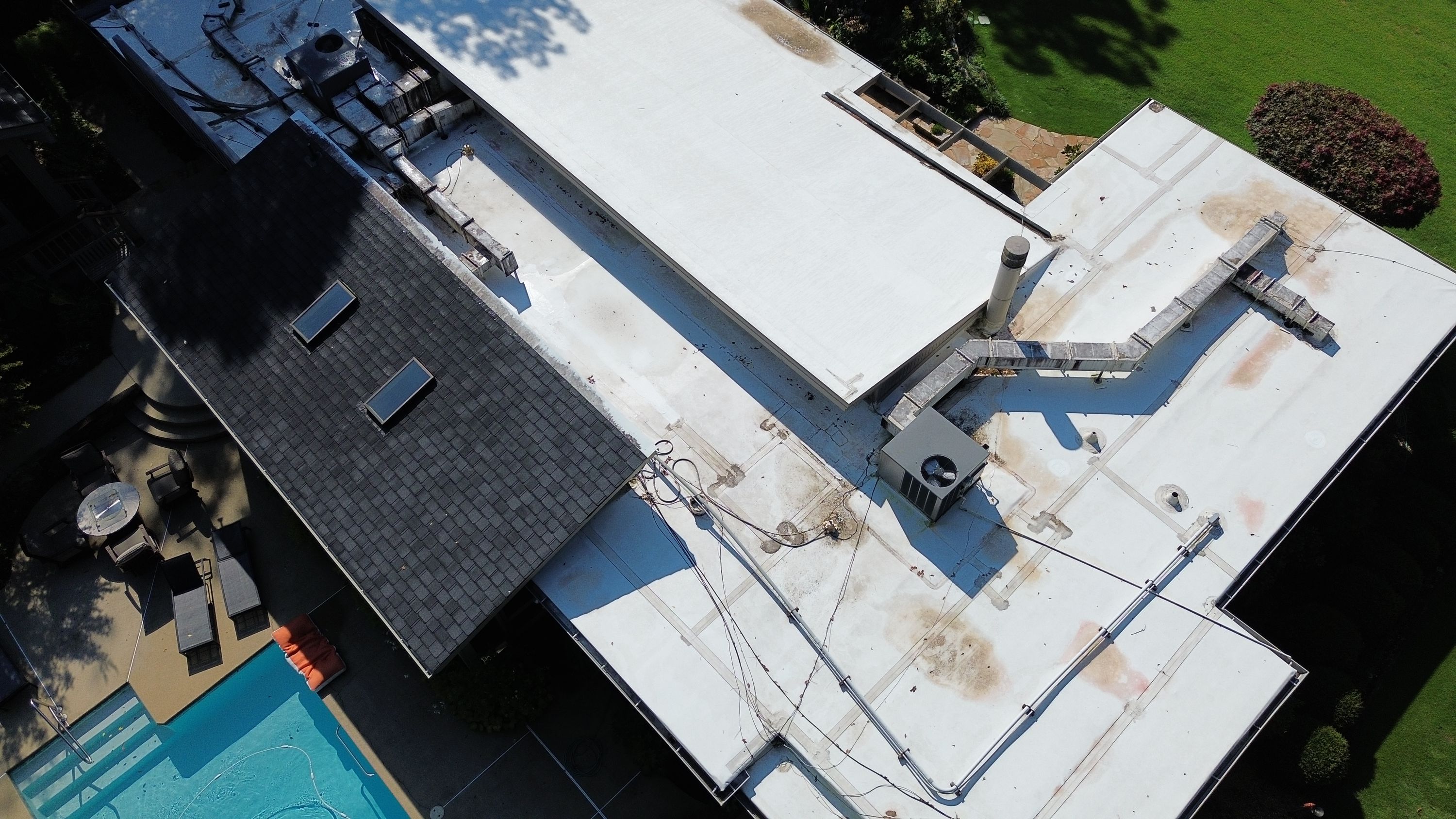 Utility lines run across the newly prepped flat roofing membrane during a Mountain Brook roof replacement.